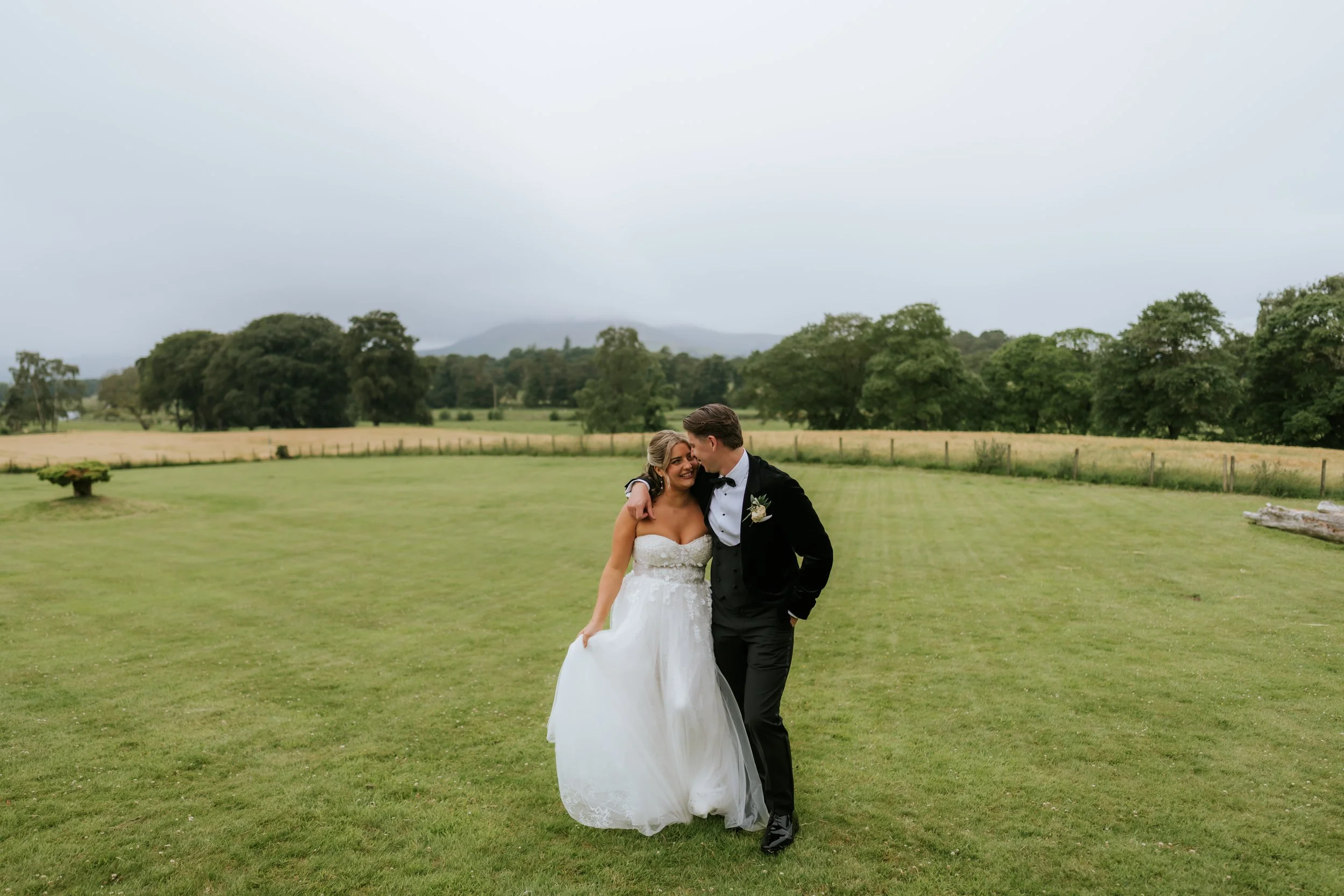 Emma and Frazer walking together across the castle lawn.