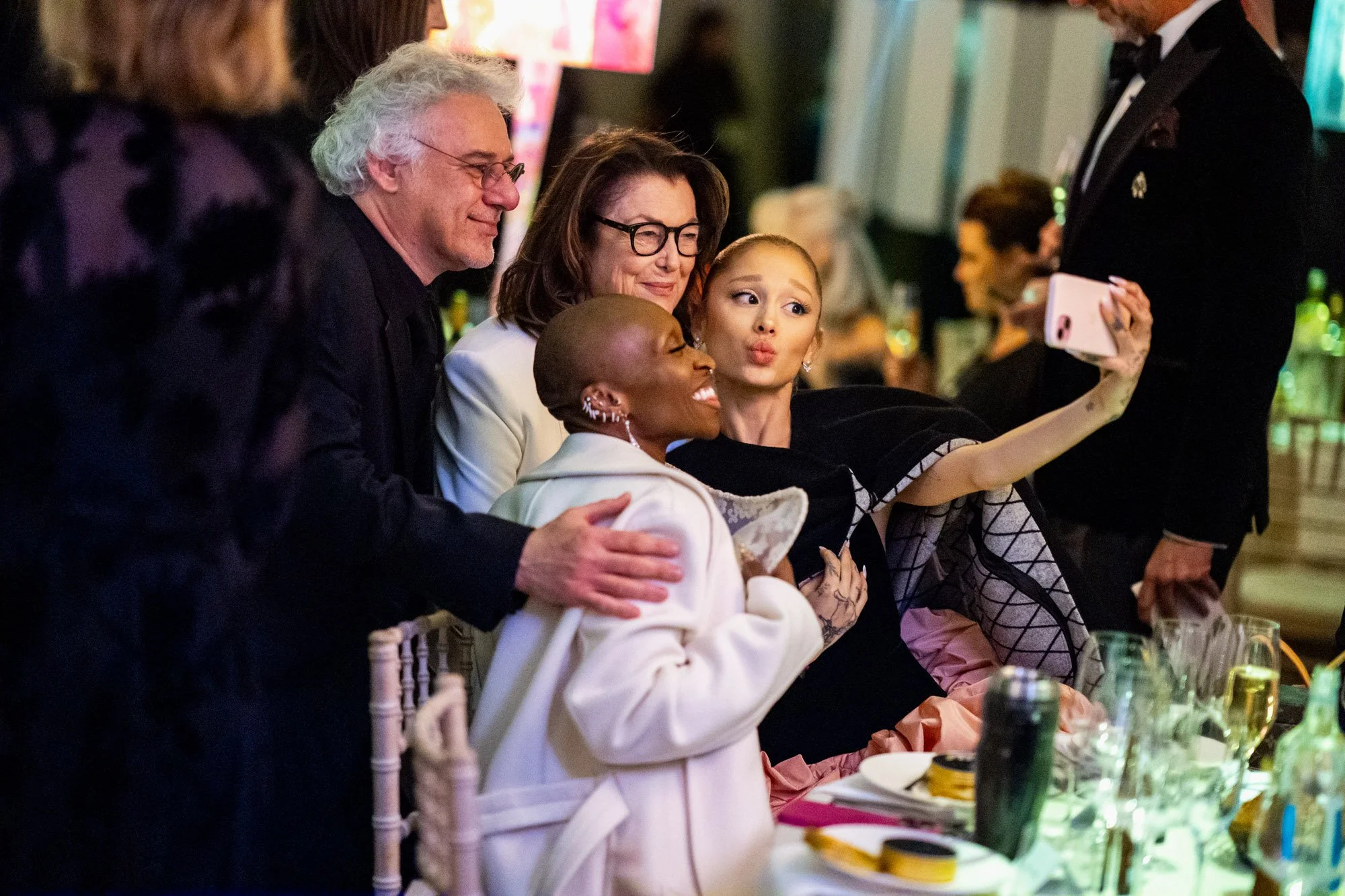 Ariana Grande and Cynthia Erivo taking a group selfie at the 2025 BAFTA Film Awards dinner.