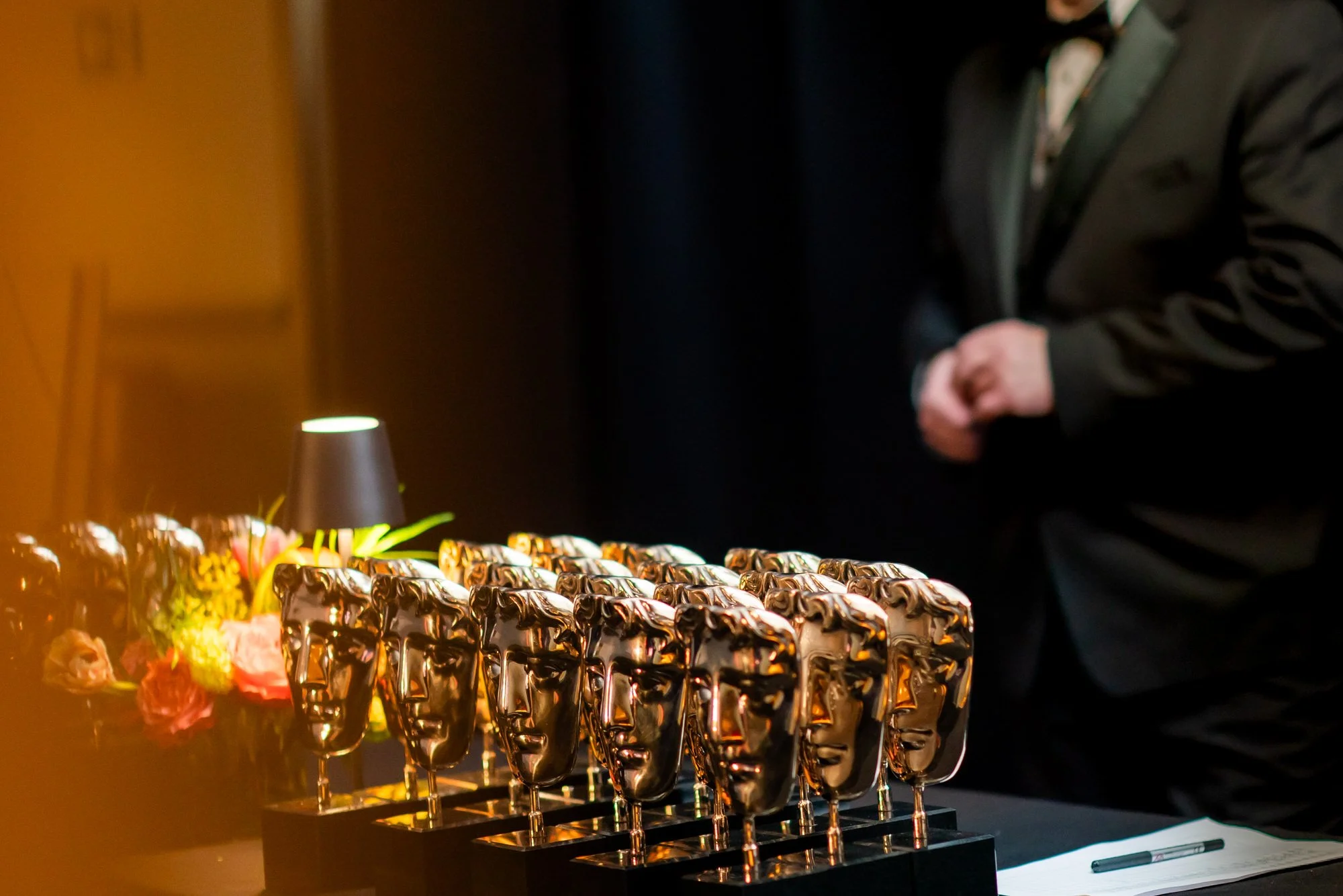 Rows of BAFTA trophies on a backstage table before the Film Awards ceremony.