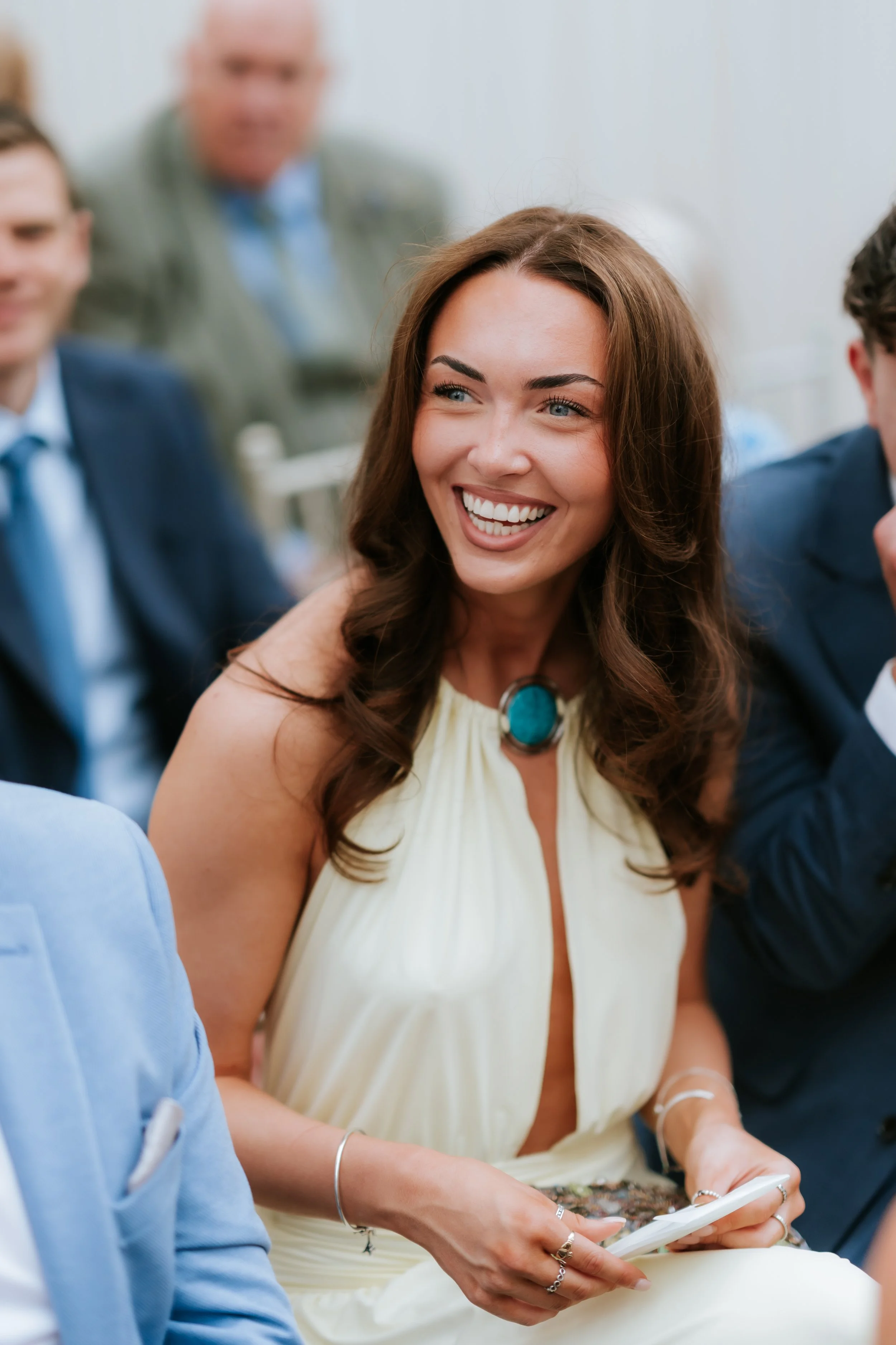A wedding guest smiling across the table during the reception.