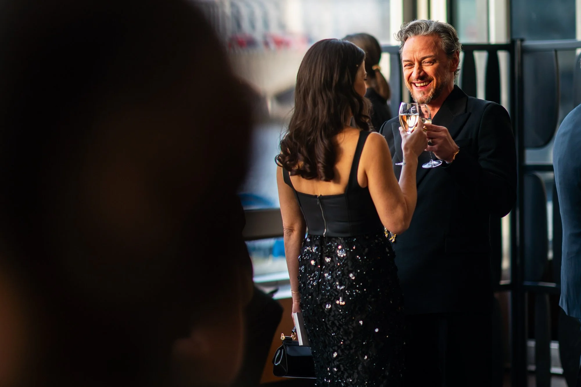 James McAvoy sharing a glass of champagne with his wife at the 2025 BAFTA Film Awards.