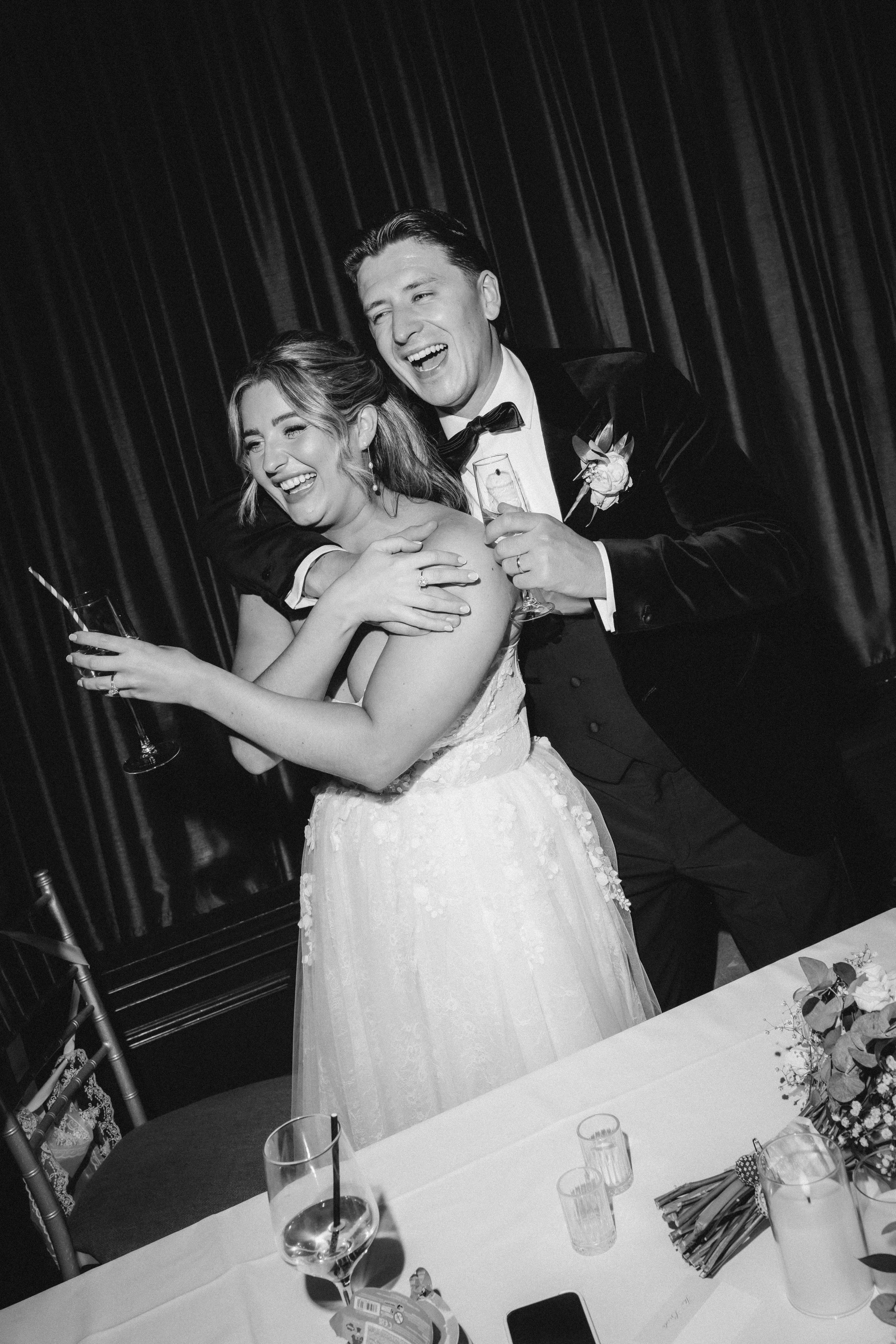 Emma and Frazer embracing beside the top table after the speeches.