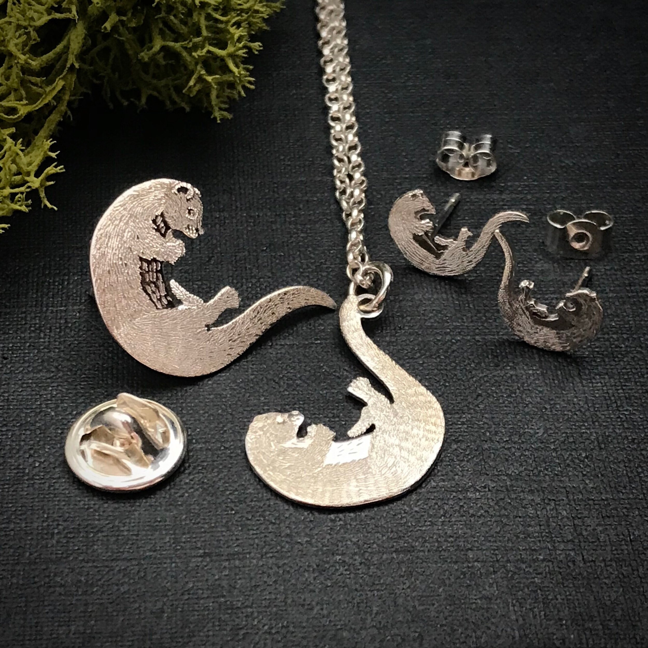 Silver Playing Otter Jewellery, including pendant, earrings and lapel pin.