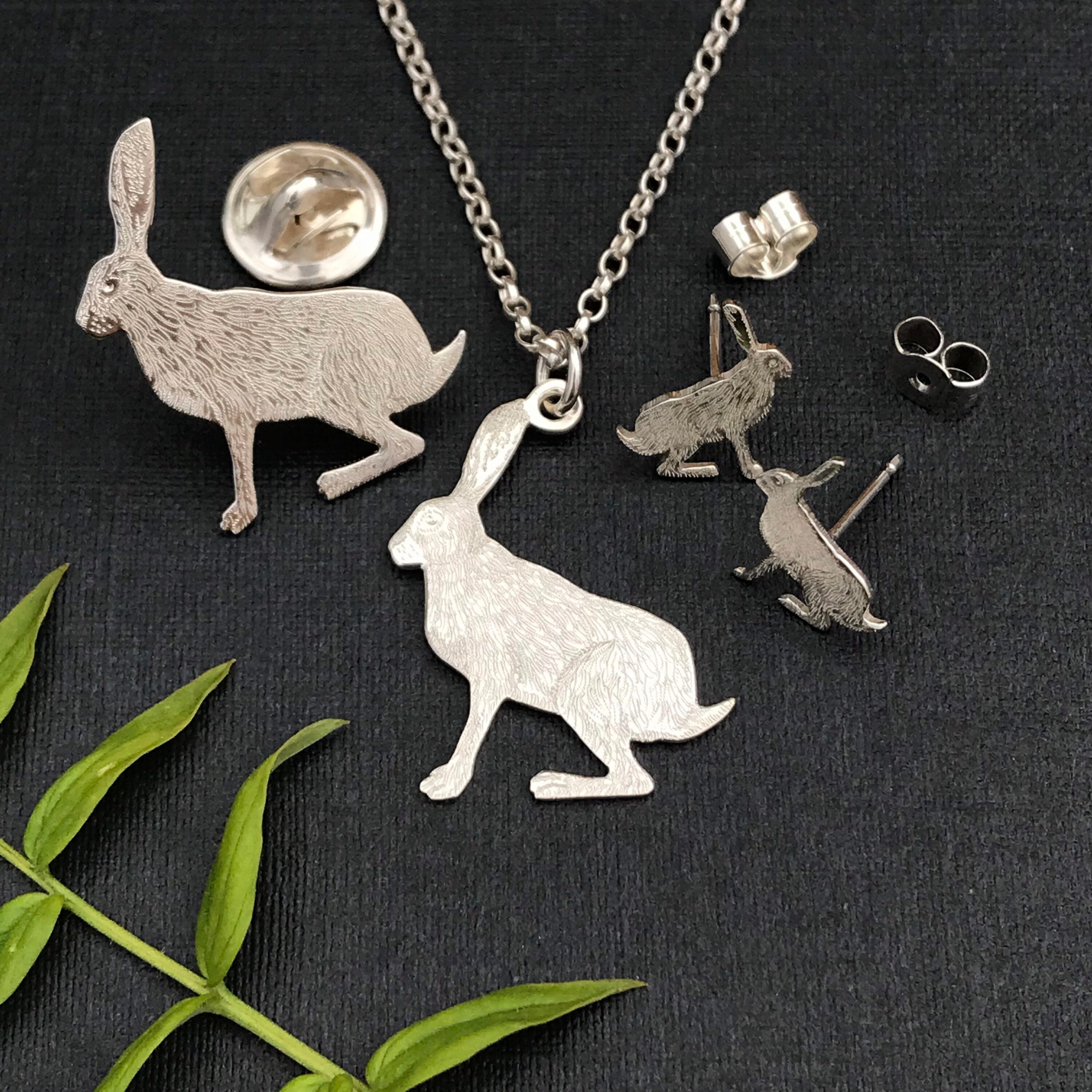 Silver sitting Hare jewellery including pendant, earrings and lapel pin.