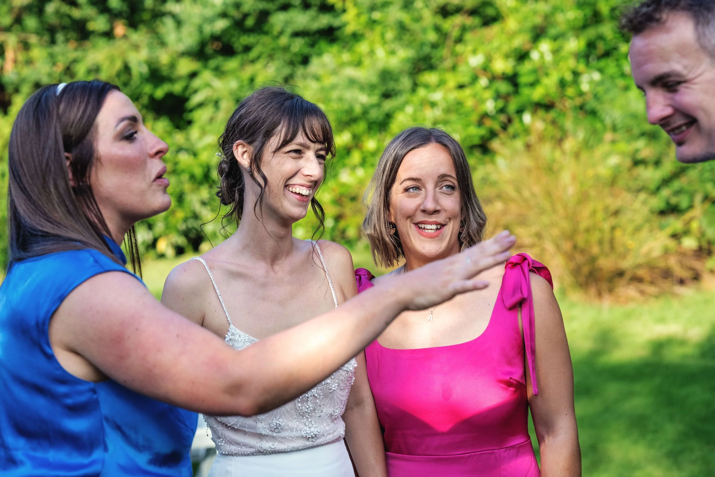 Laughing bride with bridesmaid and groom
