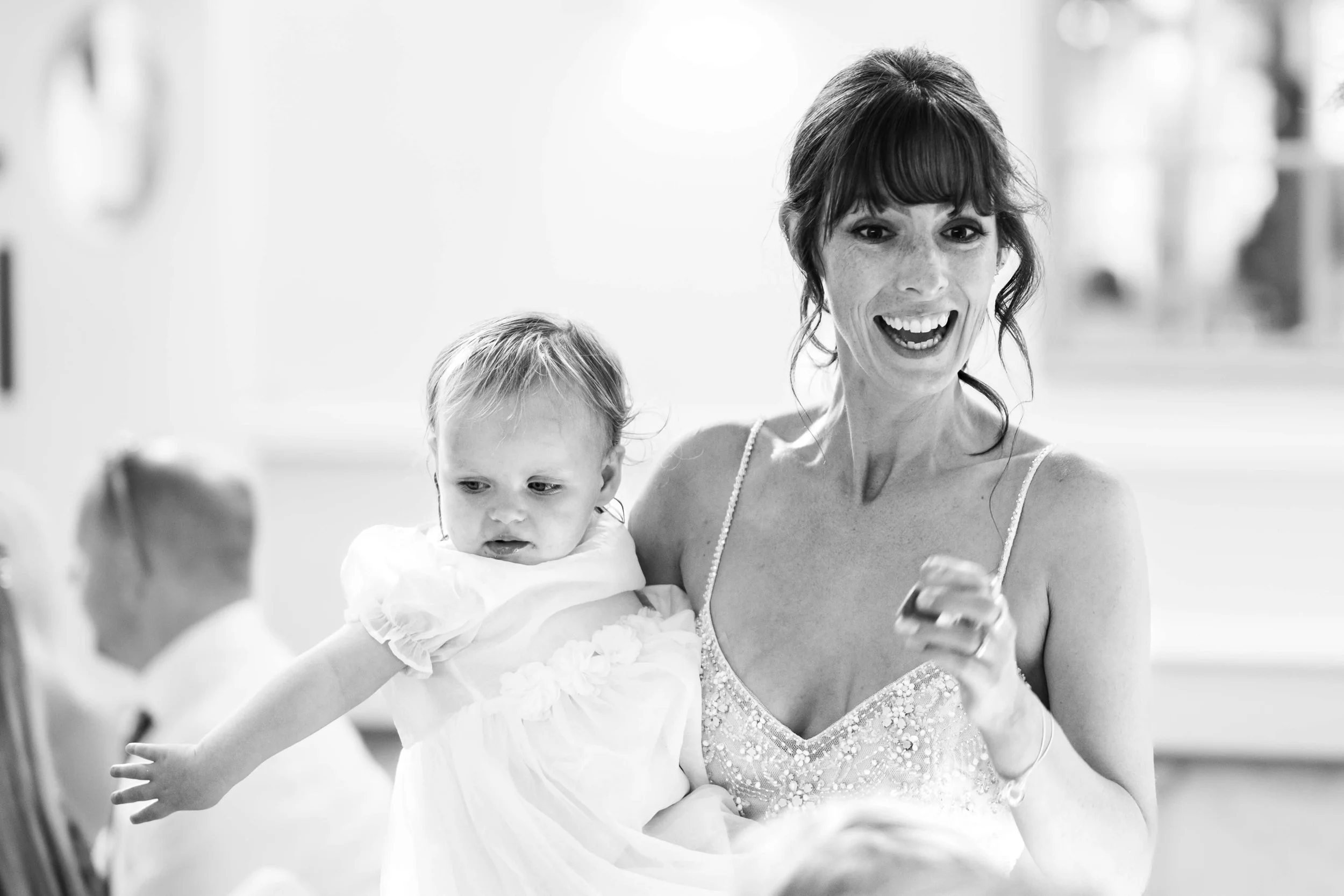Bride holding child in black and white at Cottesmore Hotel Golf & Country Club