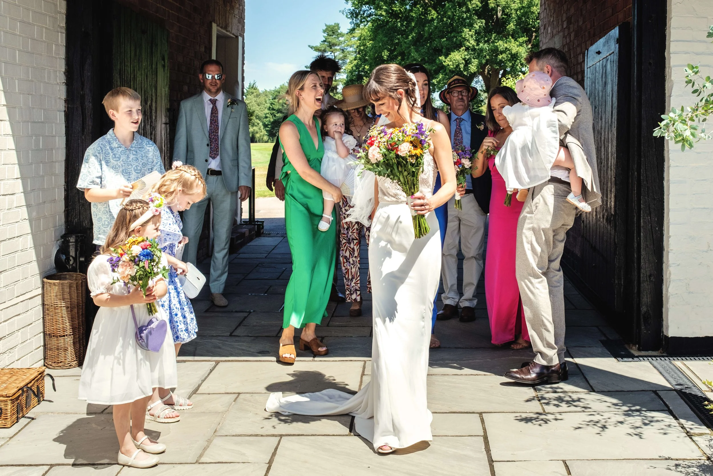 Bride with flowers waits in sunshine