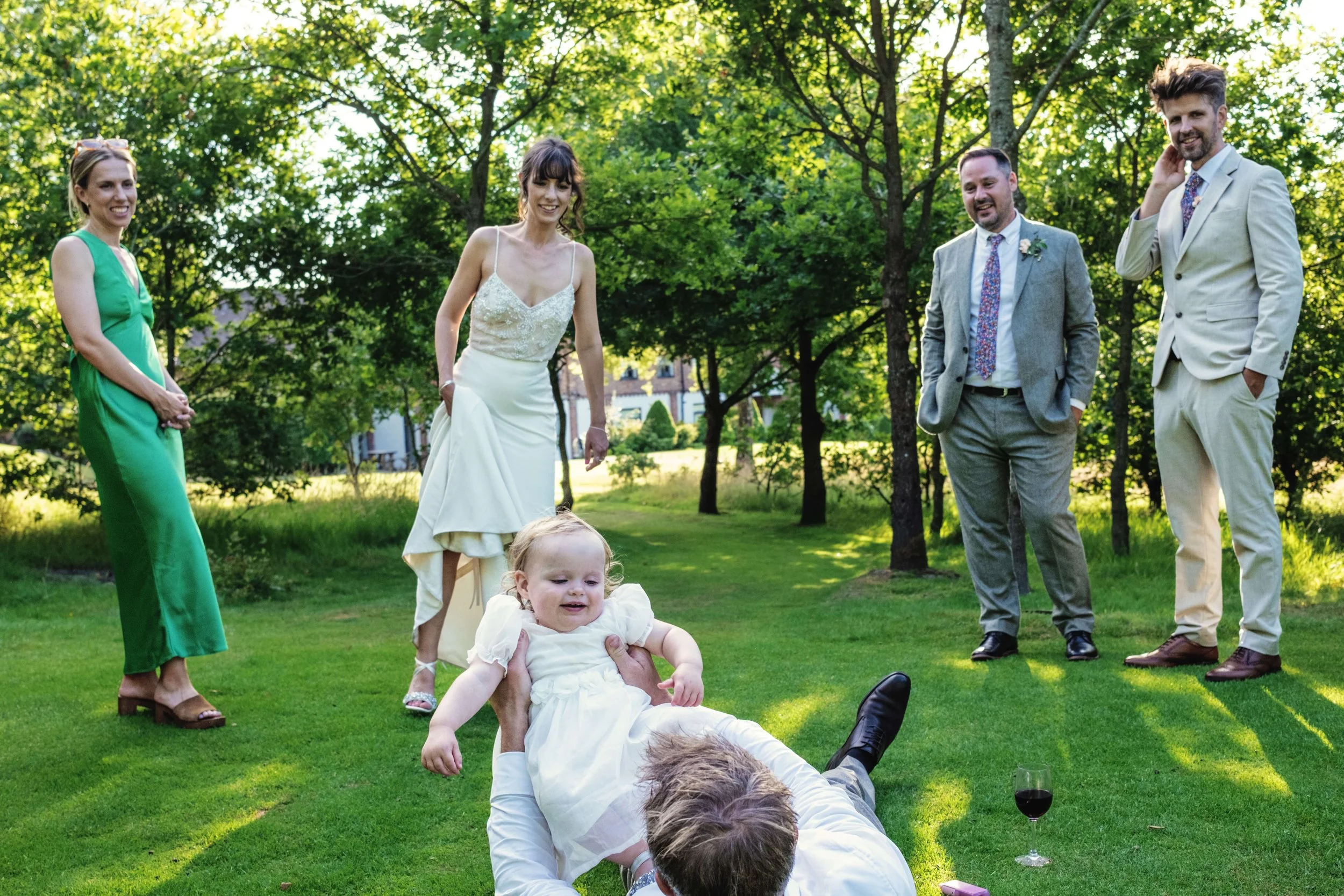 Bride and groom play with child