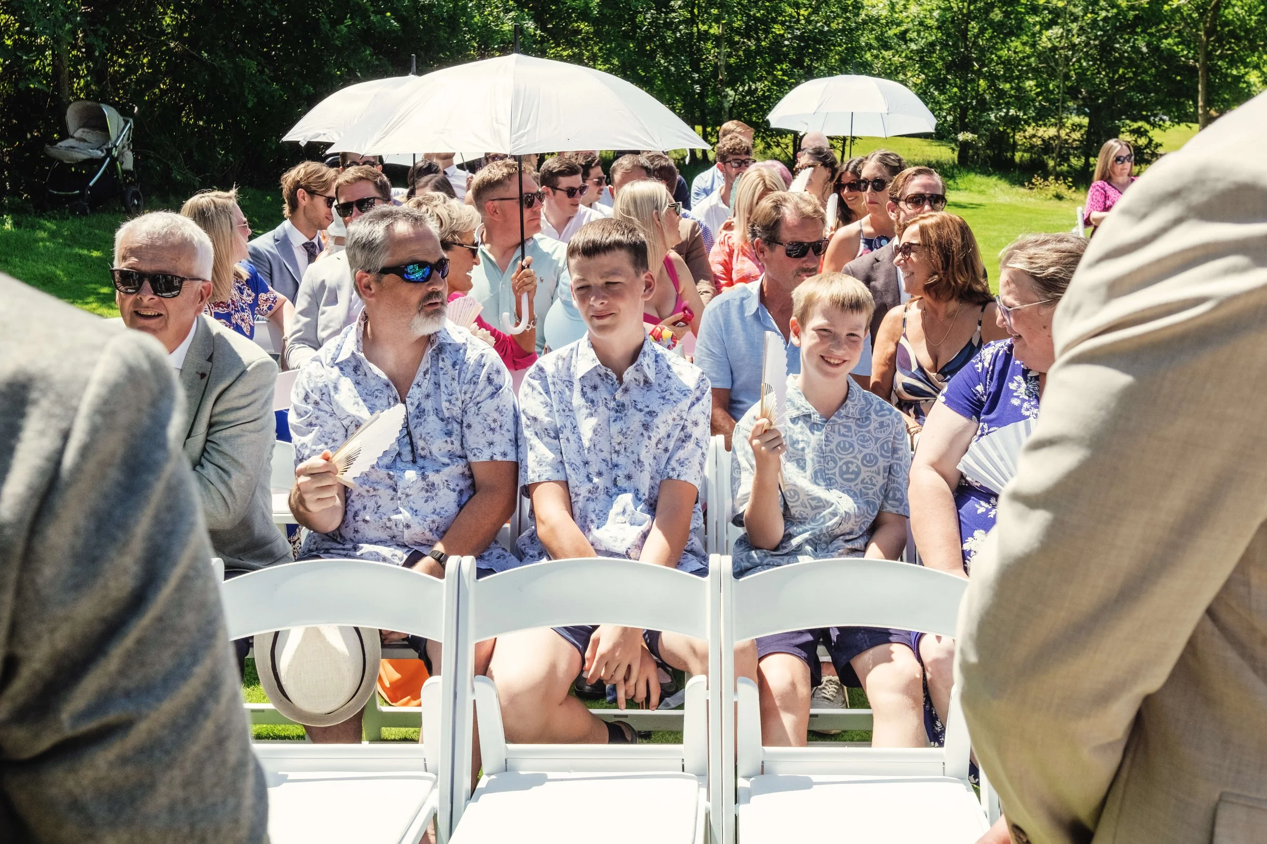 Wedding guests wait in sunshine