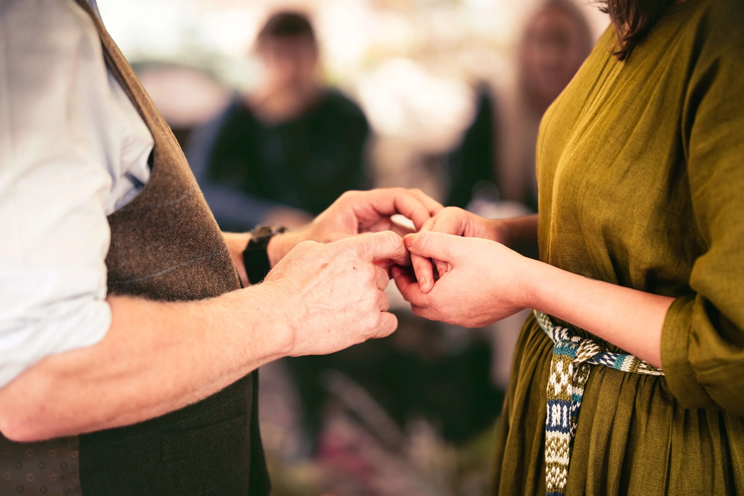 couple hold hands at hand fasting in forest