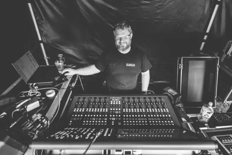 Callum Jones of Pro Audio Services smiling behind a mixing console.