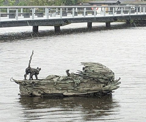 A bronze statue, "Beatrice's Cradle" floating in a body of water