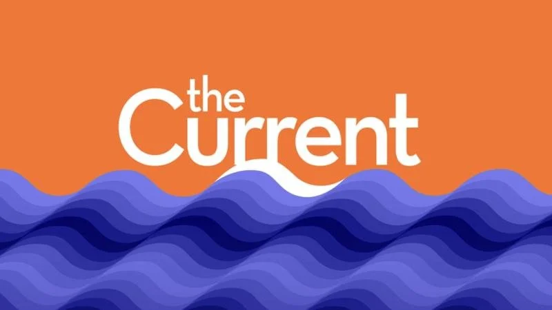 The logo of 'The Current' with stylized waves in purple at the bottom and an orange background.