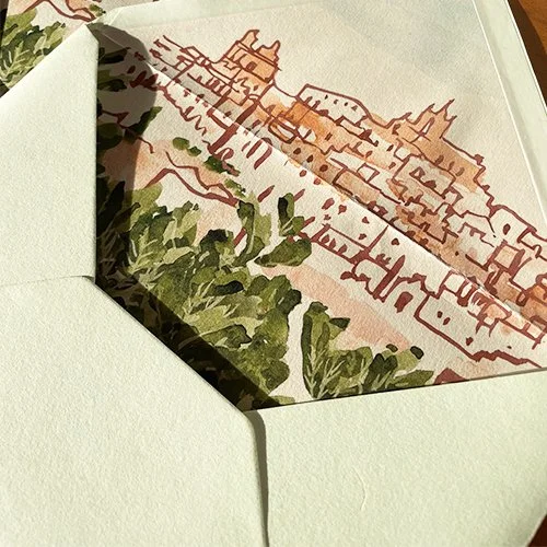 Close-up of an envelope with a cityscape illustration on the inside flap, showing buildings and greenery.