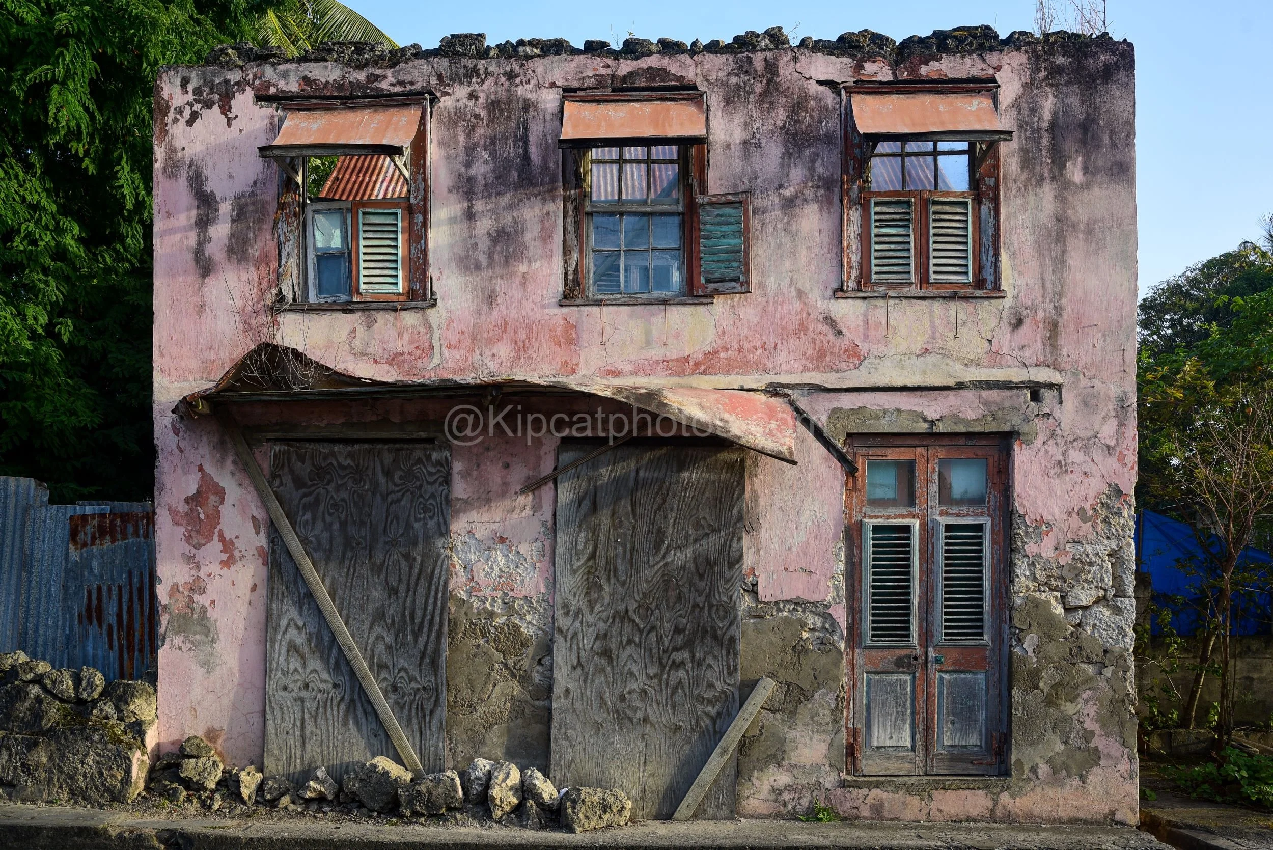 A crumbling roofless house in Speightstown, Barbados.

A crumbling, old pink stucco house with no roof, in Speightstown with shutters and jalousie windows