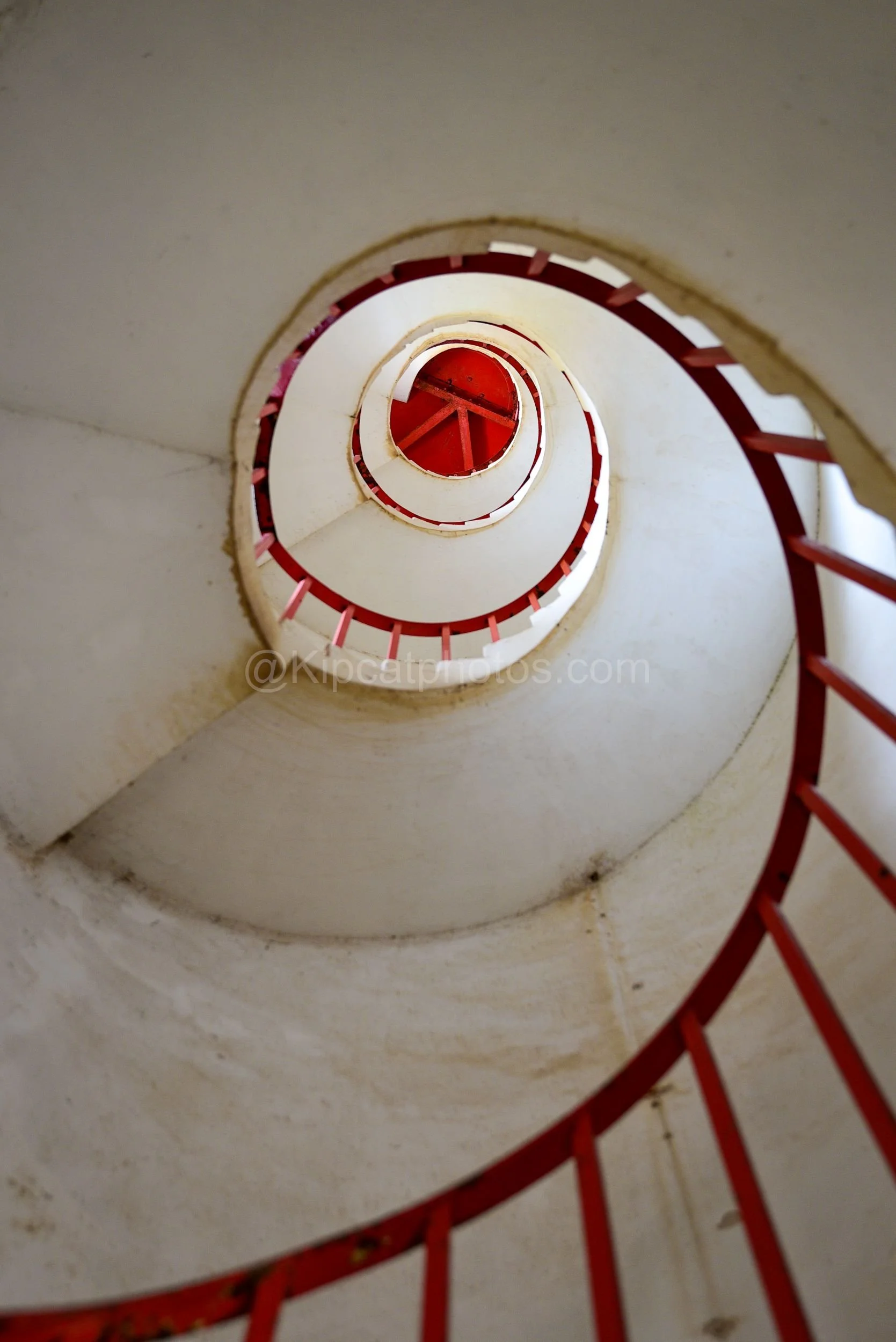 Looking up a spiral staircase with a red handrail inside a Harrison's Lighthouse on Barbados. Kipcatphotos.com

A dizzying view up Harrison's lighthouse's spiral staircase shows tier after tier of white steps and a bright red handrail curling towards