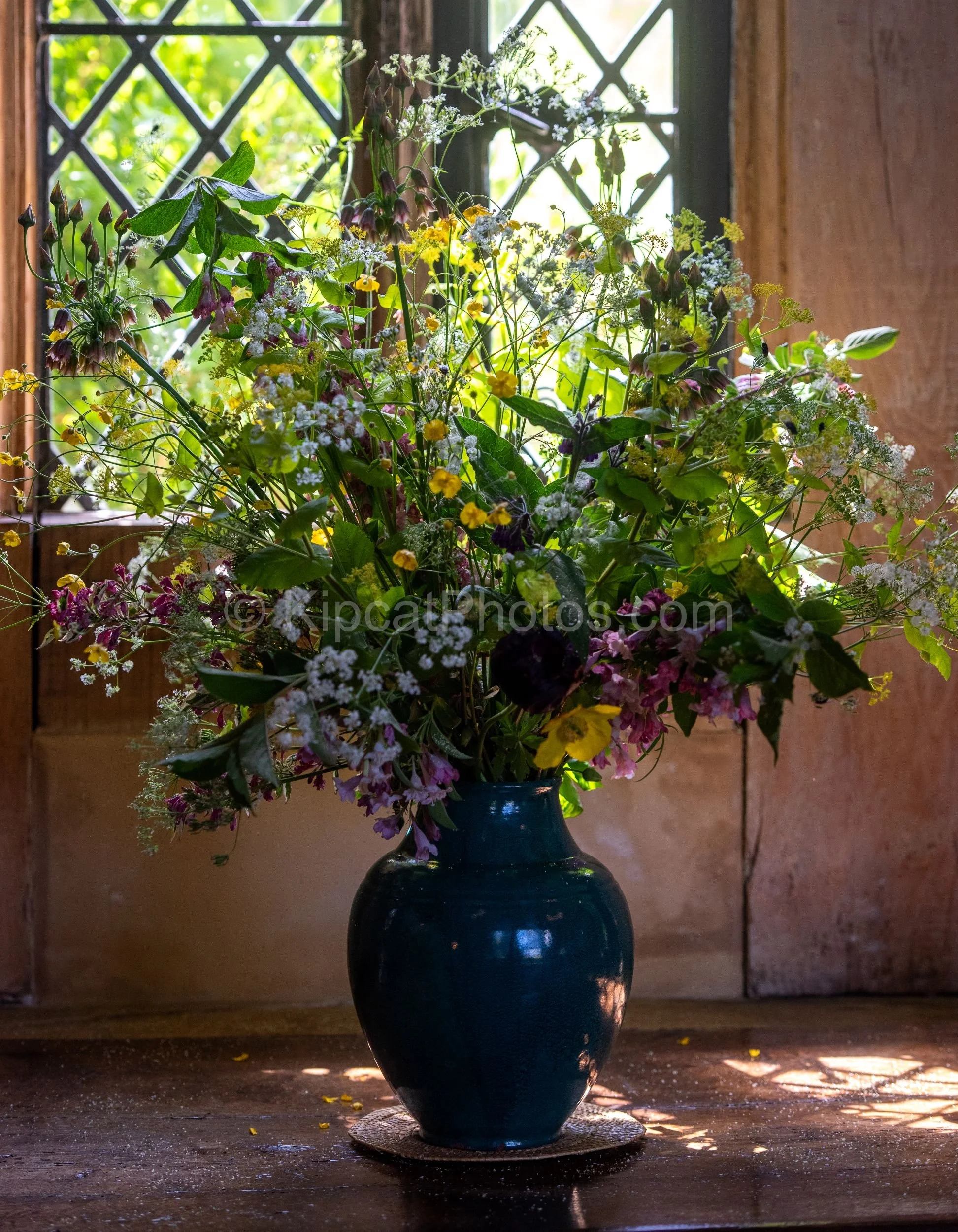 A tall, loose arrangement of wildflowers in a blue glazed jug sits in a sunlit window at Great Dixter. Kipcatphotos.com

An informal bouquet of garden-gathered wildflowers, including buttercups, cow parsley and fritillaries, spills from a glazed blue