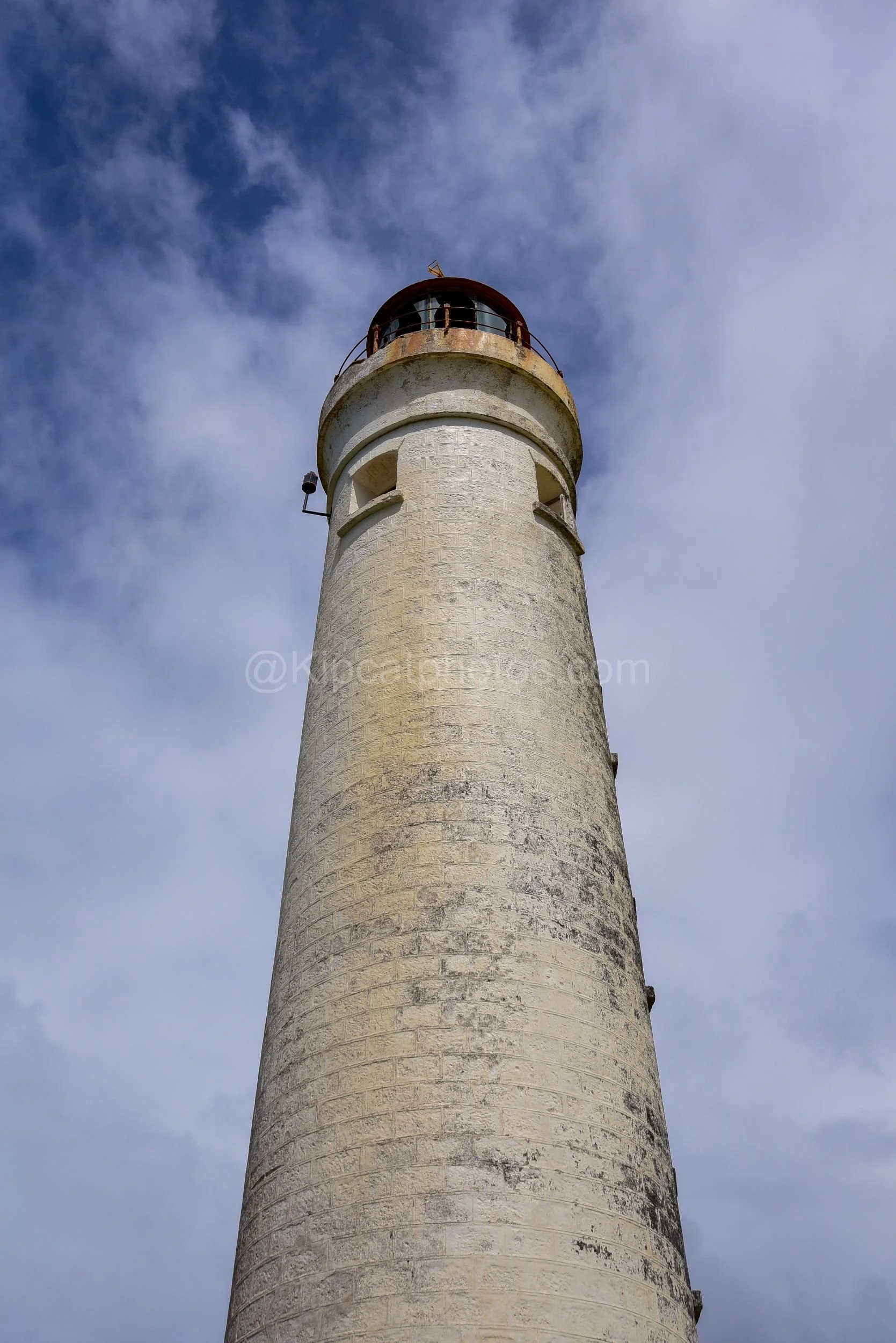 A close-up view looking up at Harrison's lighthouse tower and its rusted lantern room in Barbados. Kipcatphotos.com

Looking straight up the tapering white tower of Harrison's lighthouse reveals its textured stonework and small square windows, leadin