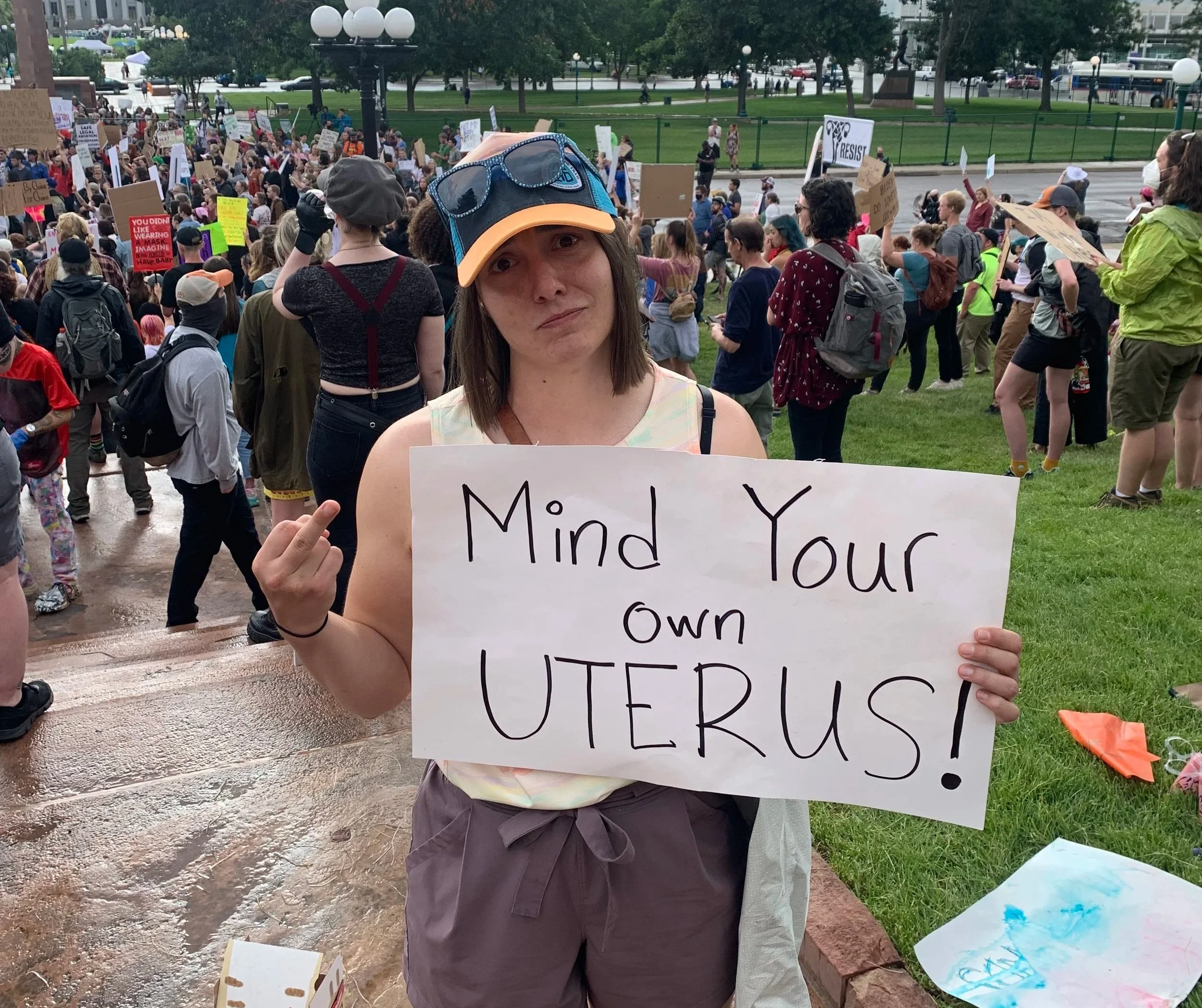Me flipping off the camera at a protest holding a sign "Mind Your Own Uterus!"