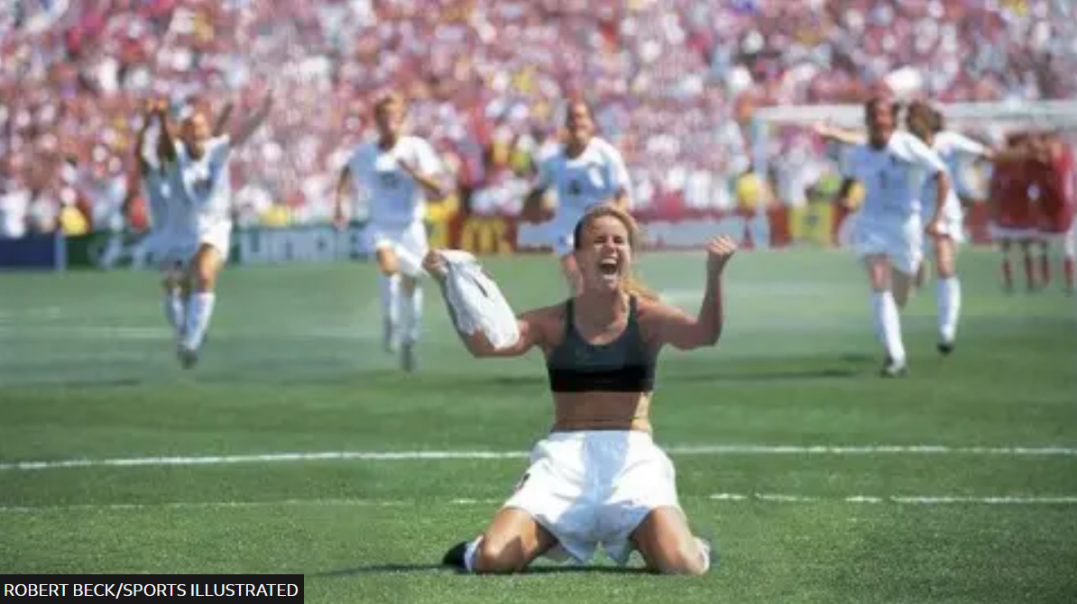Brandy Chastain holding up her shirt after scoring the game winning PK