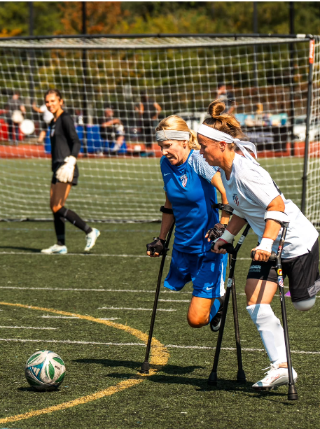 two amputee soccer players going head to head for the ball