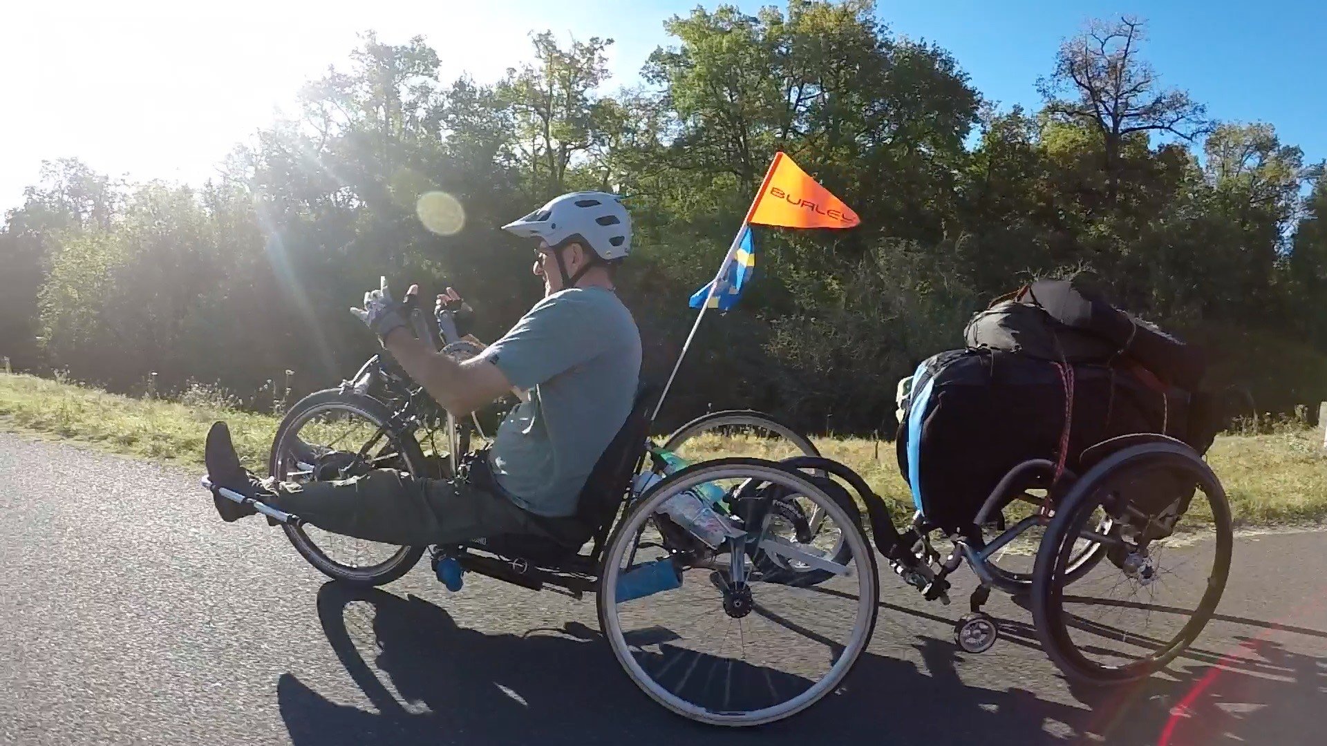 Topher cycling with his bike pulling his gear for bikepacking