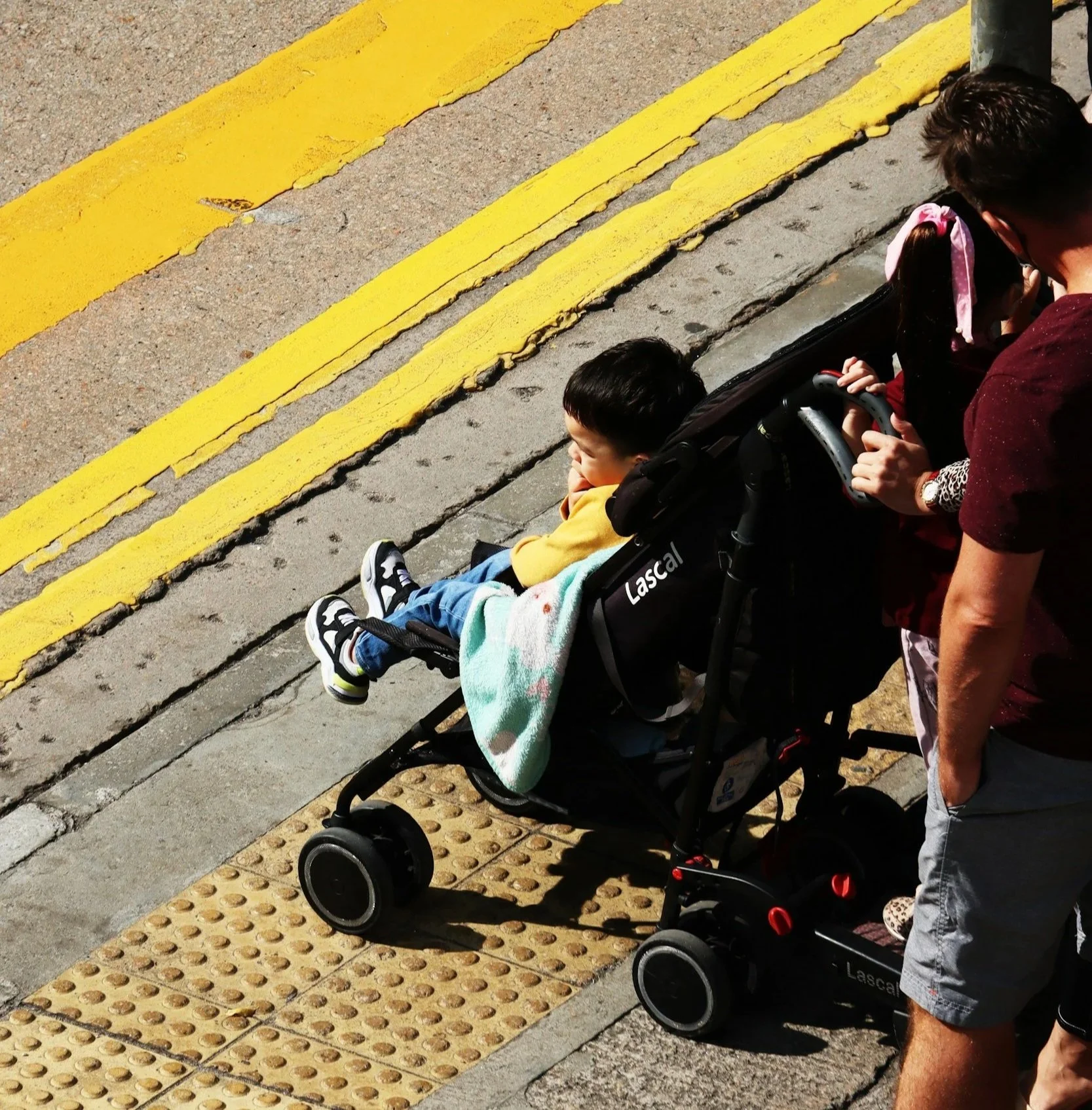 baby in a stroller at a curb cut waiting to cross the road
