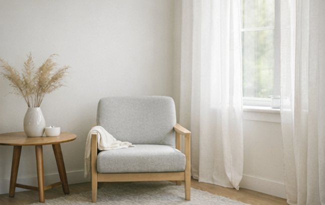 A chair positioned near a window with soft natural light, creating a calm and reflective space.