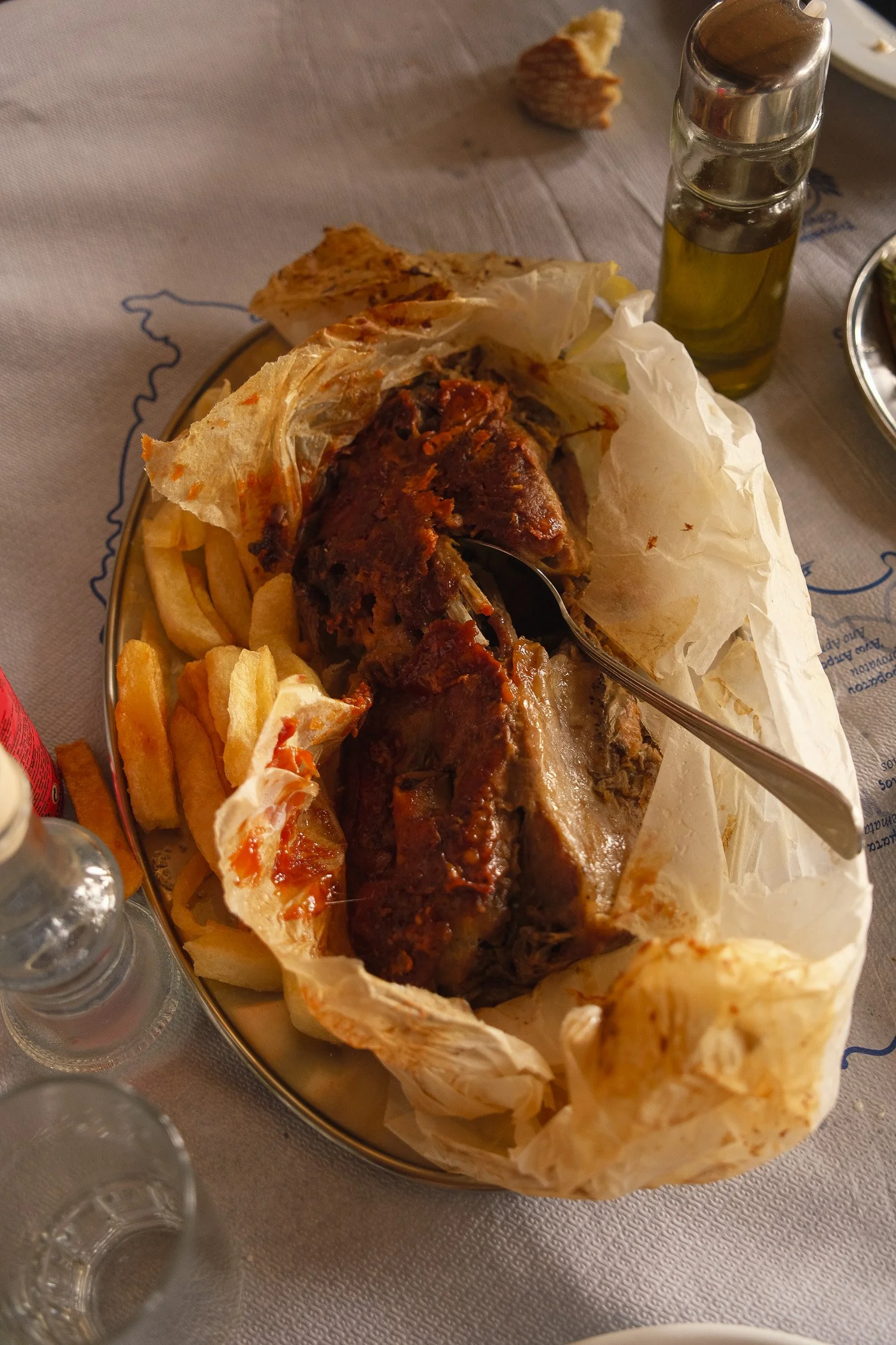 Goat baked in parchment paper served at Kossis Taverna on Andros Island, a traditional Greek dish enjoyed during a slow travel experience.