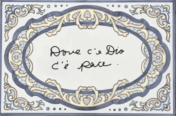 Decorative framed handwritten Italian ceramica reading 'Dove c'e Dio c'e' pace', which translates to "Where there is God, there is peace."