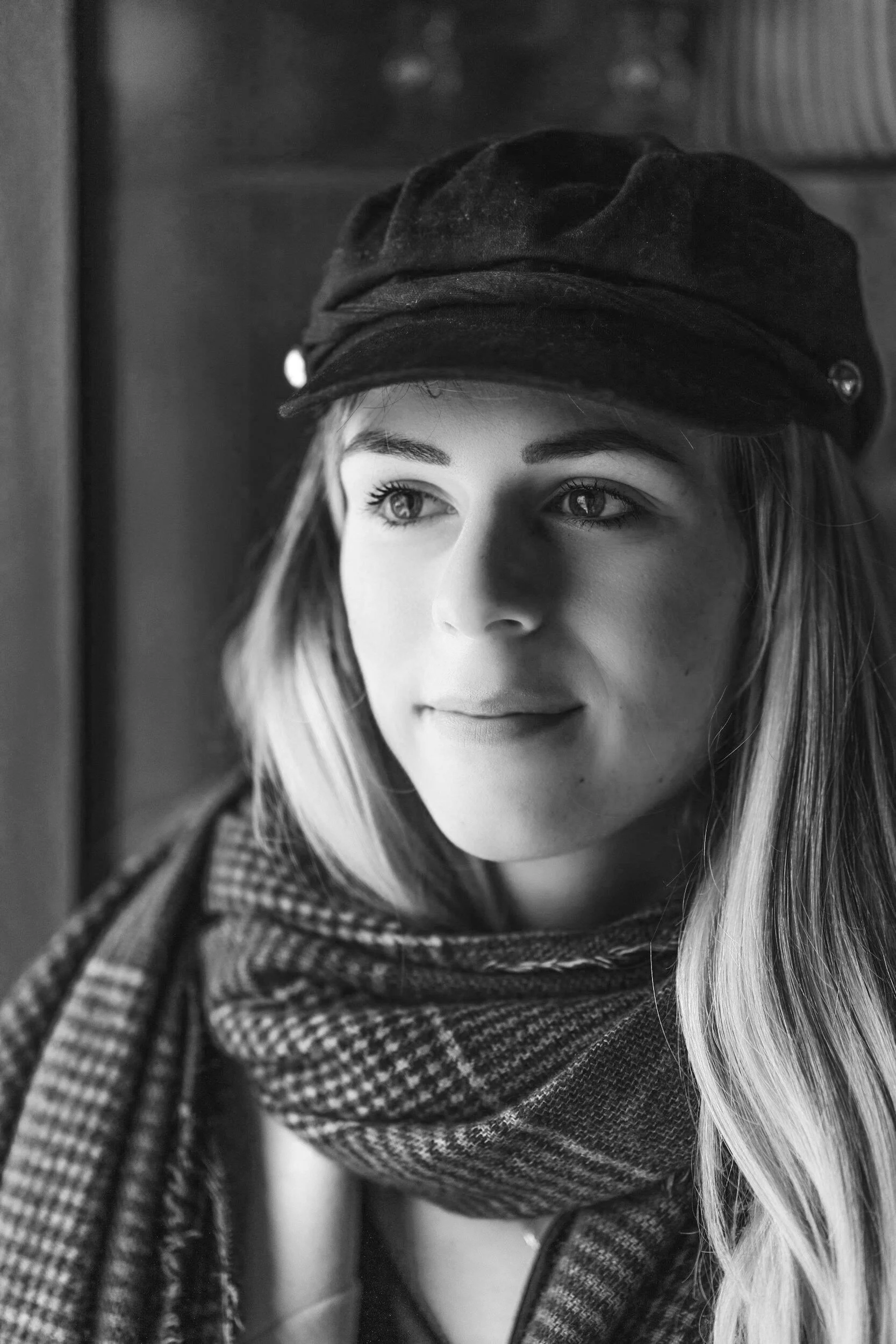 Miss Stella, wearing a dark hat and a patterned scarf.
