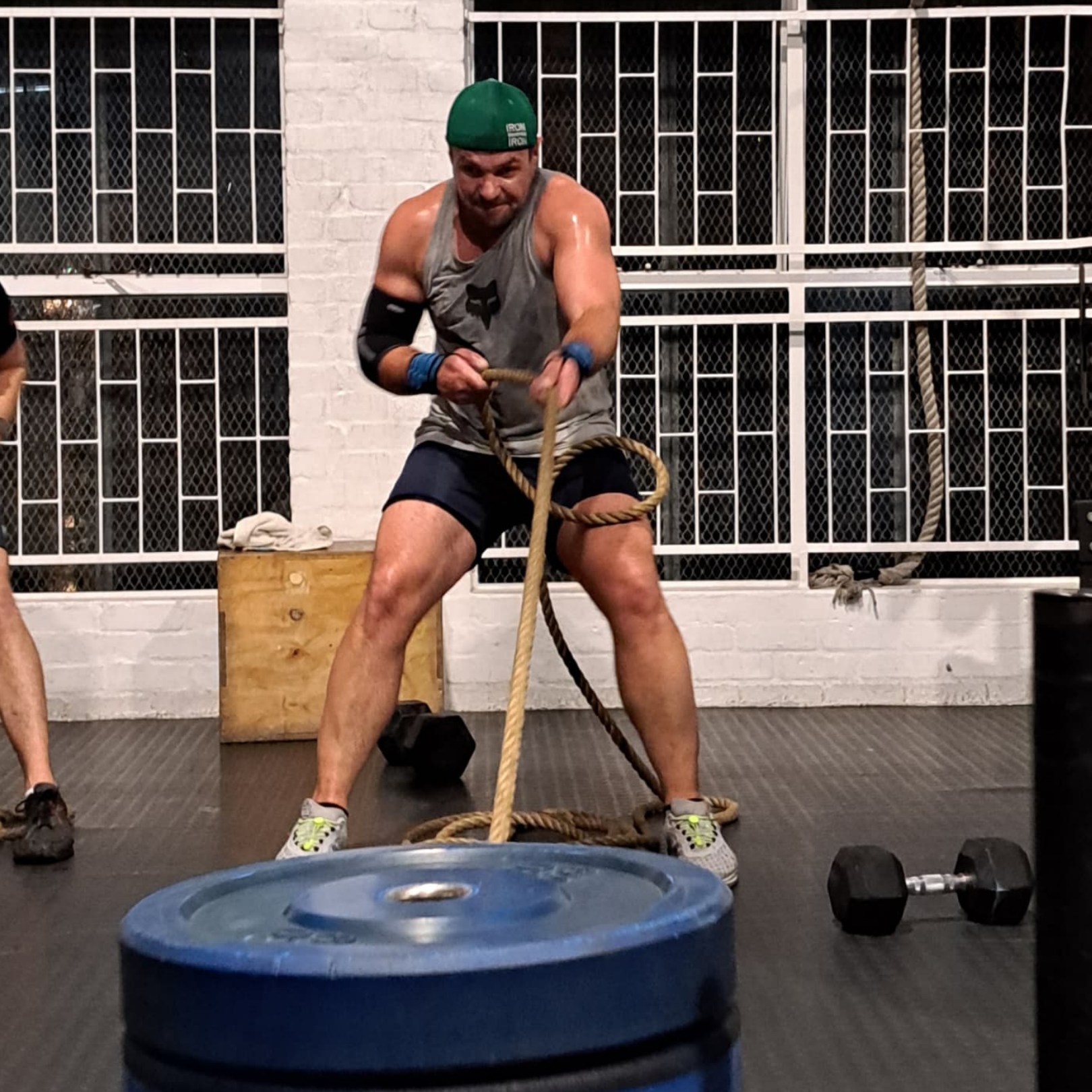 man pulling prowler sled in crossfit gym