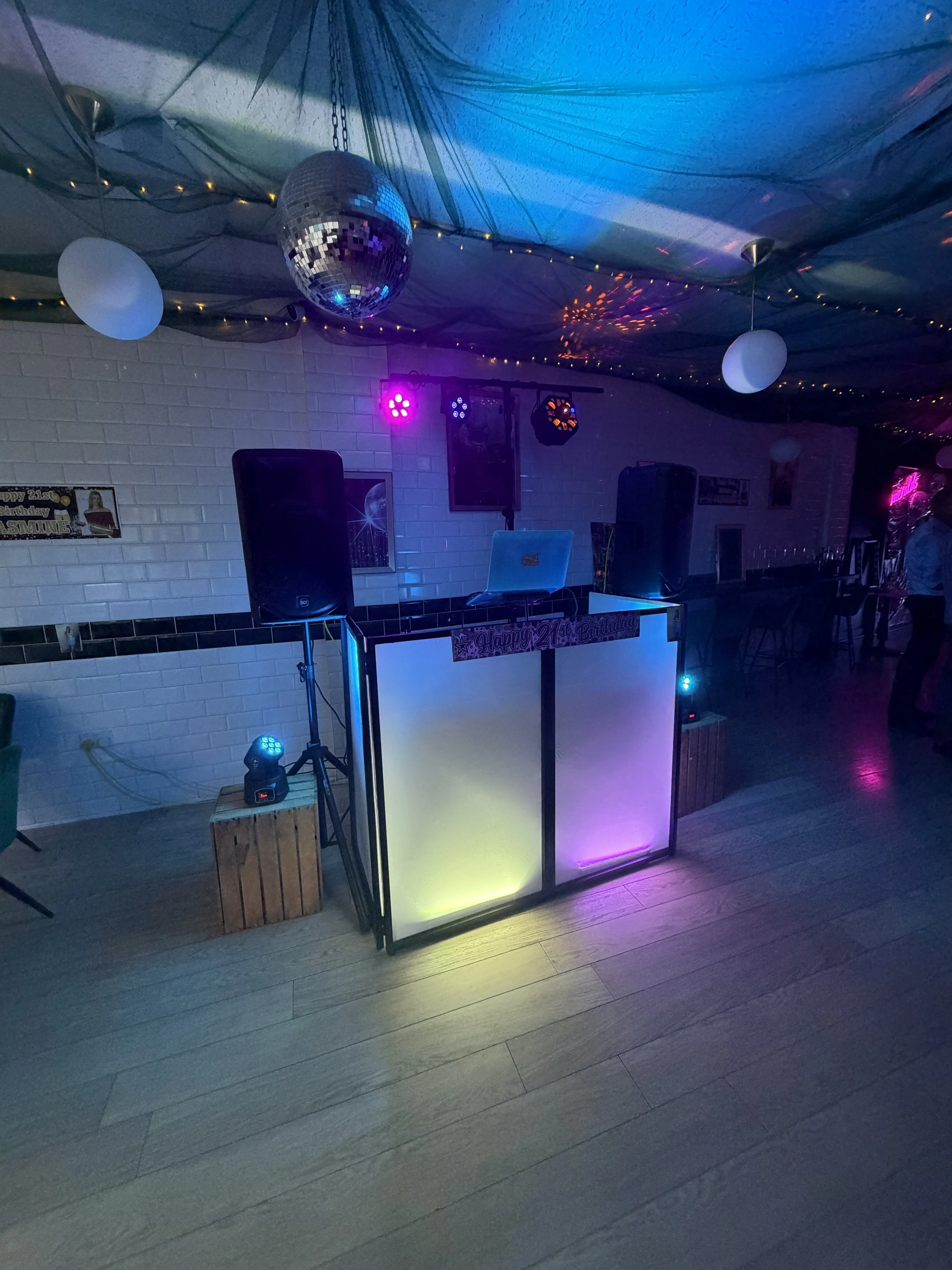 Indoor 21st birthday party with DJ booth, speakers, colourful lighting and balloons. At Emeralds Chelmsford