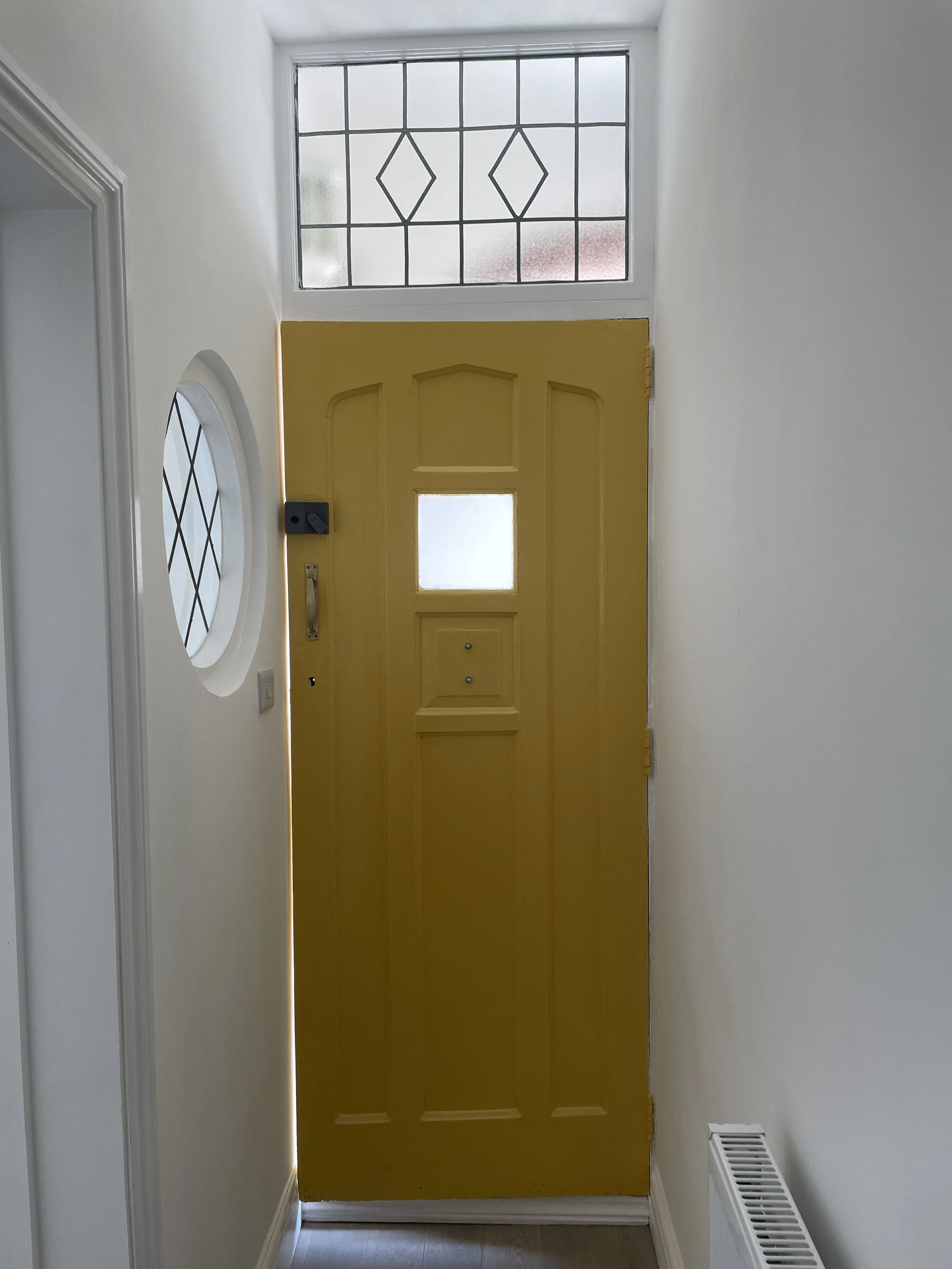 Refurbished interior hallway with yellow painted front door