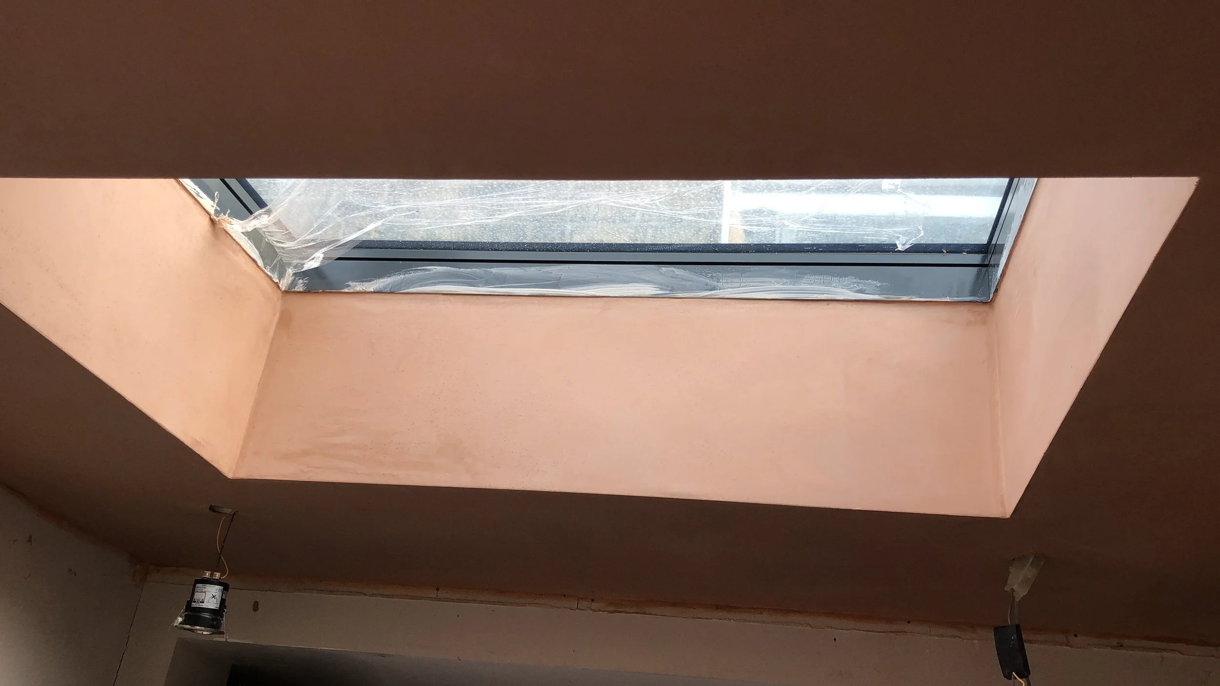 Freshly skimmed plaster wall below a skylight