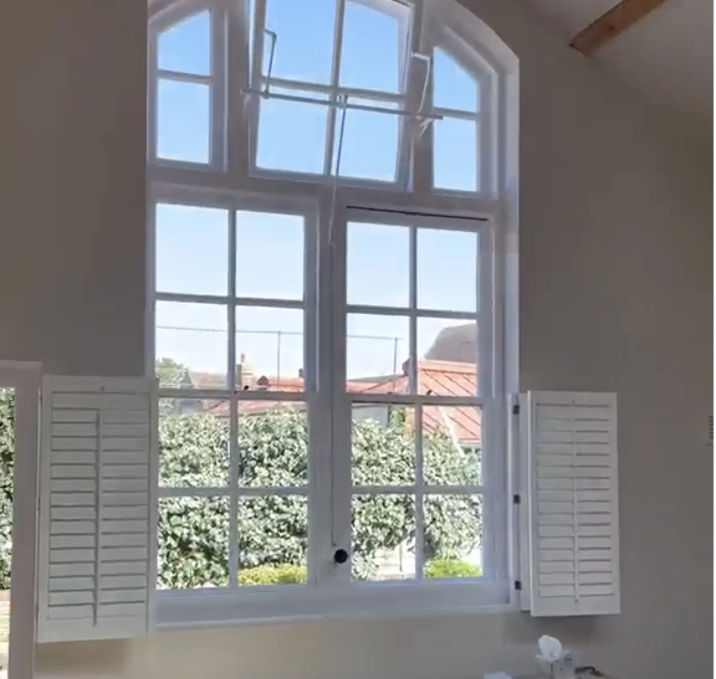 Refurbished room with arched window and white shutters, South London