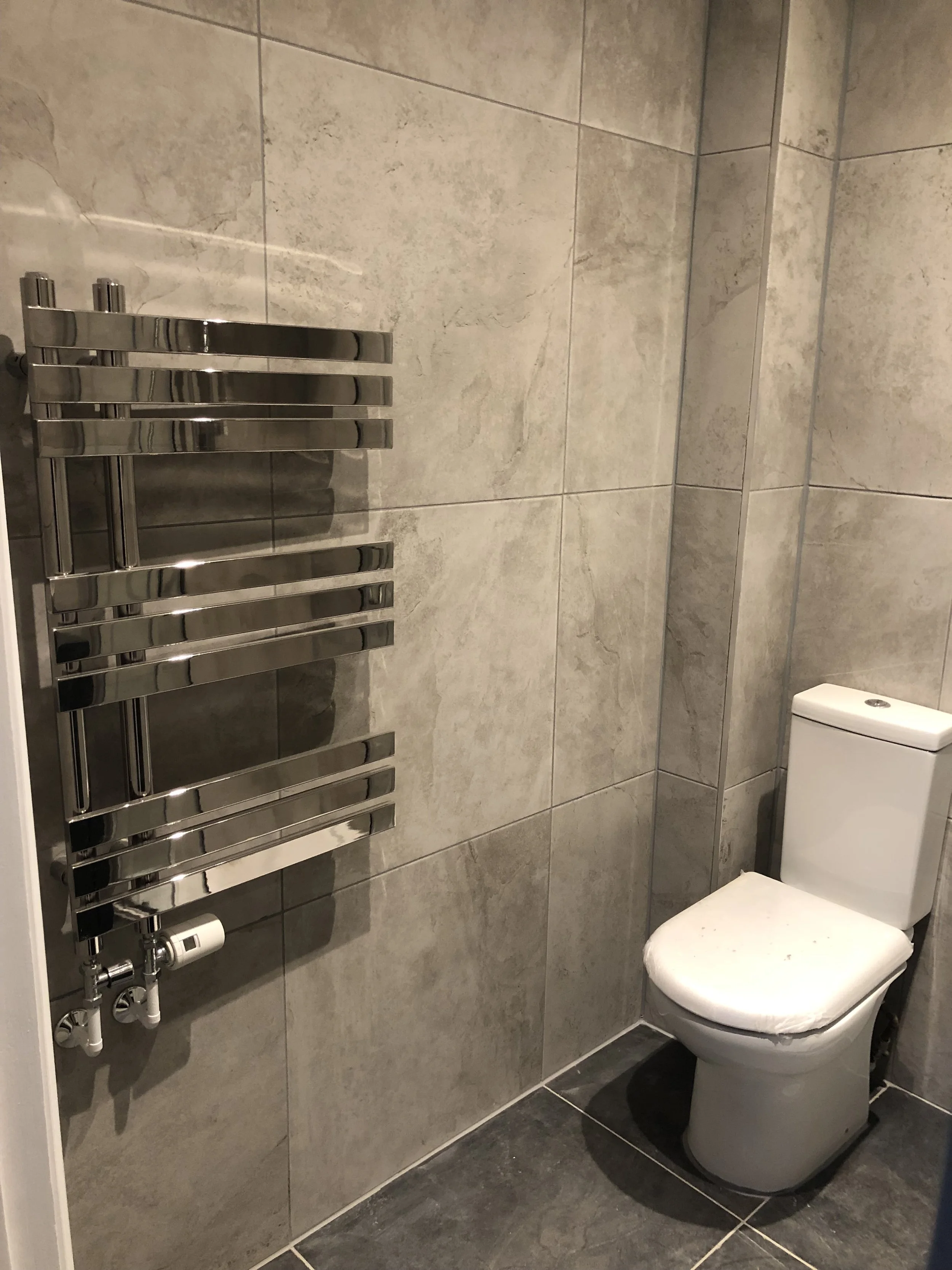 Refurbished bathroom with heated towel rail and toilet