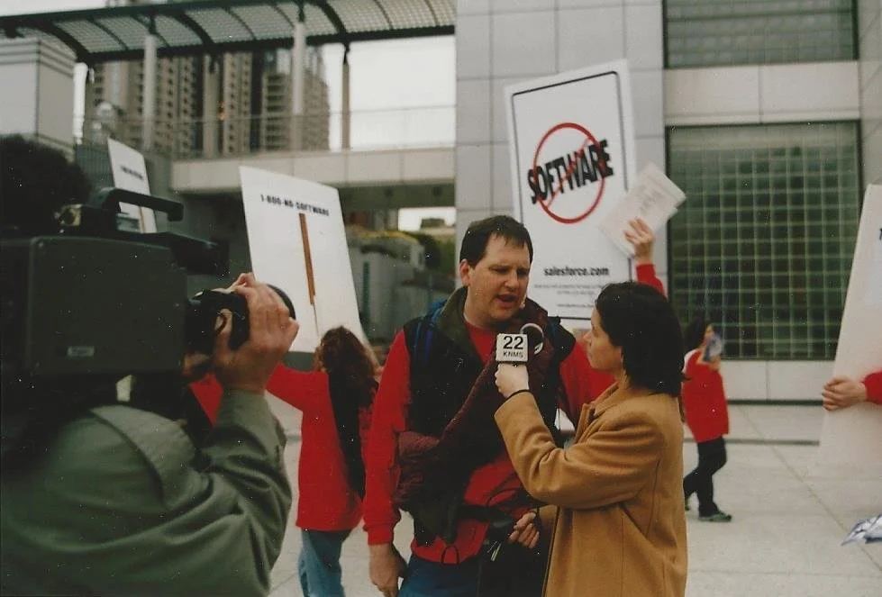 An image of Benioff getting interviewed at the 2000 “End of Software” protest.