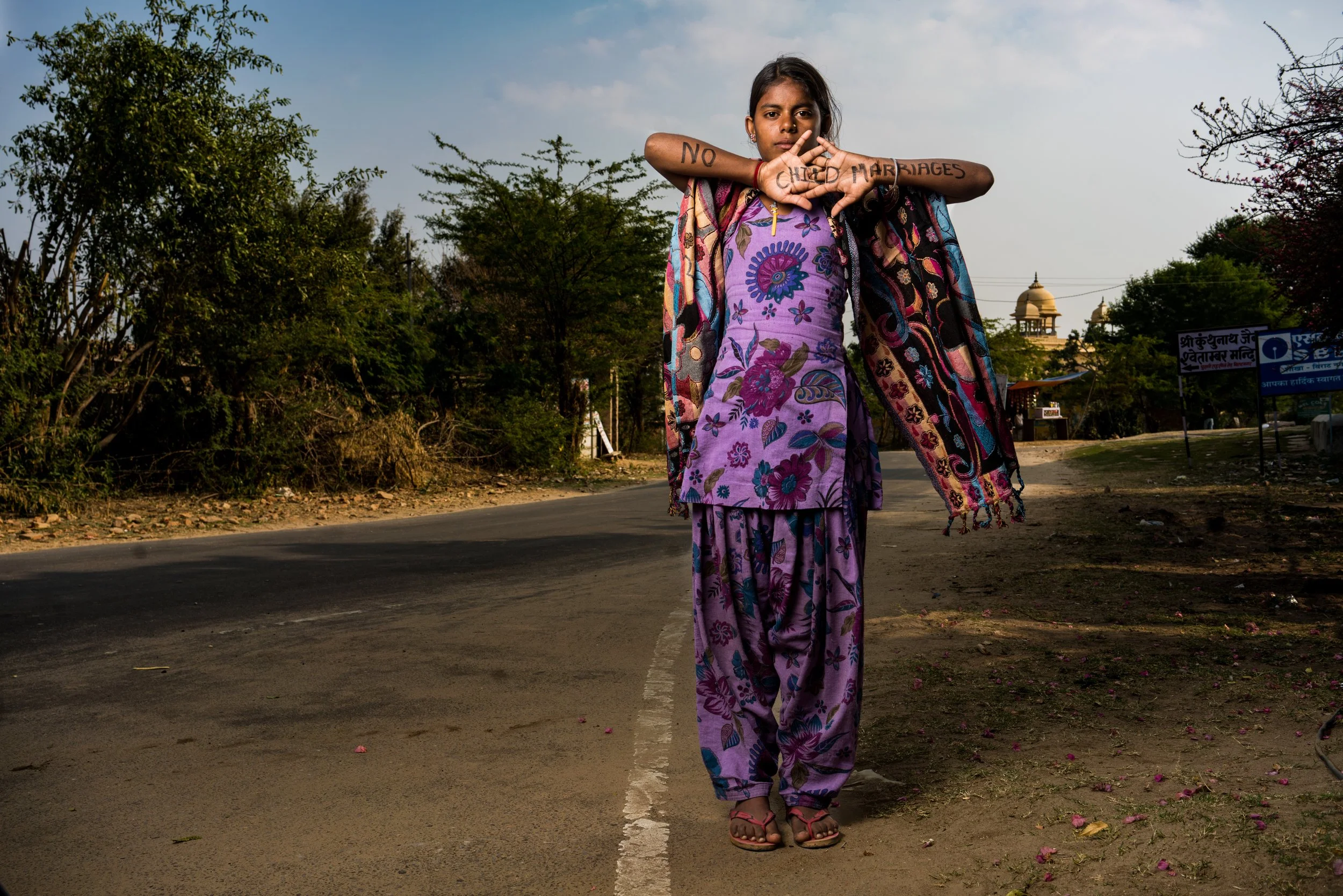 Young girl in Delhi with hands that say no child marriage.