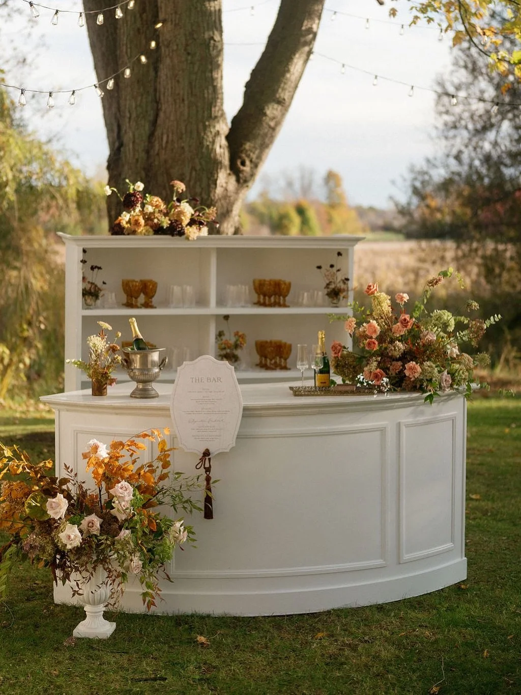 Autumnal Reverie 🍂 | Part III
 Cocktail Hour - Just steps from the ceremony, the celebration continued beneath a canopy of string lights and wistful willows &mdash; where laughter mingles with the soft hum of golden fields stretching endlessly in th