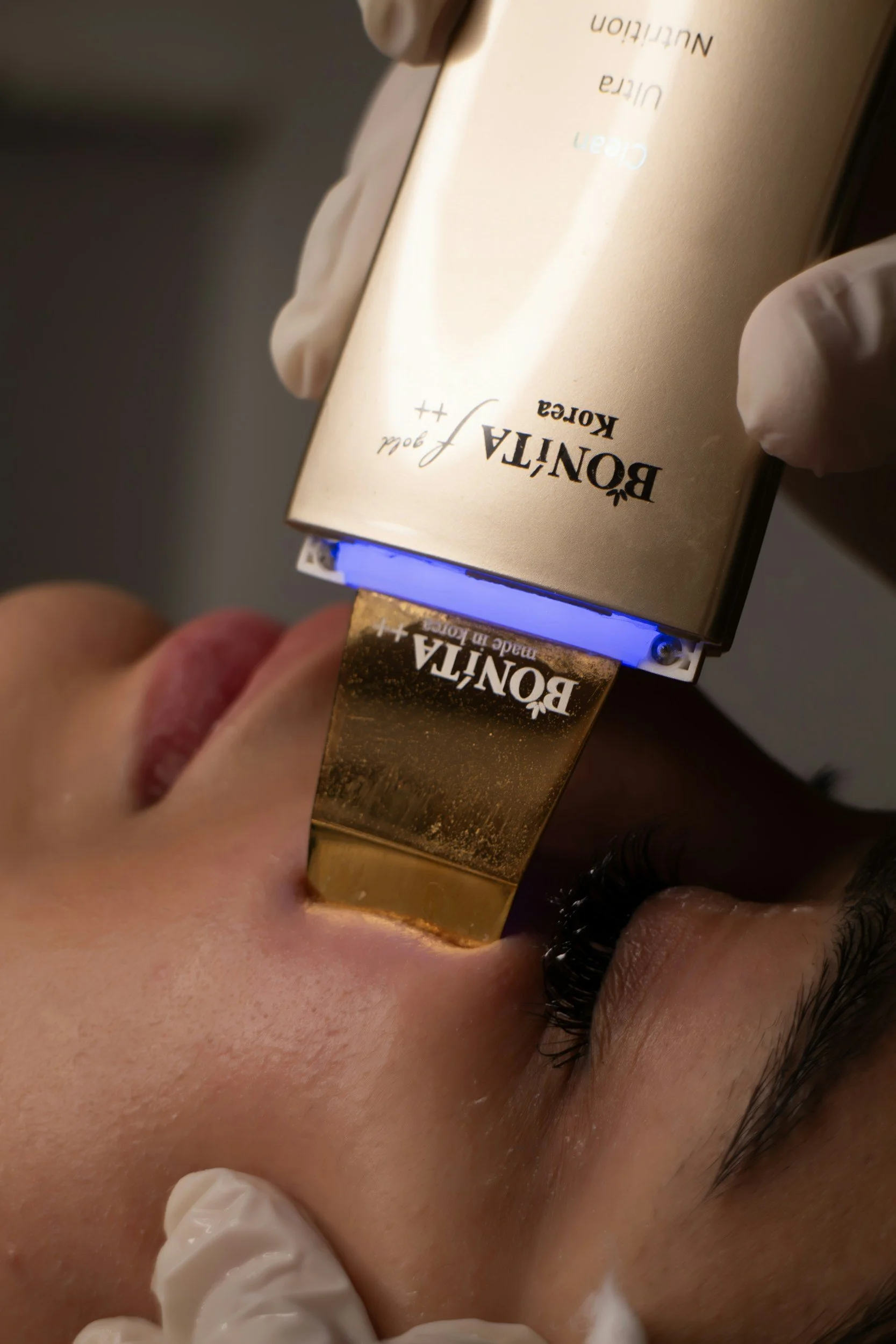 Person performing a sound bath facial treatment