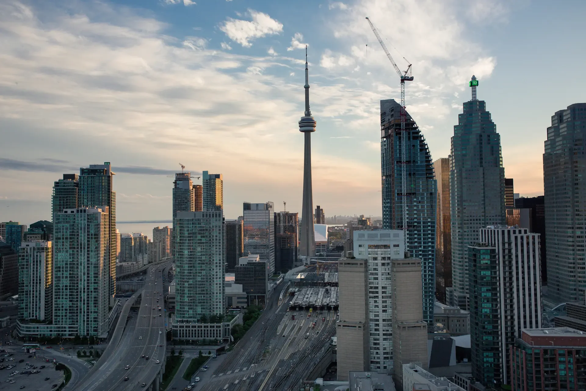 Toronto skyline during sunset featuring the CN Tower and several high-rise buildings.