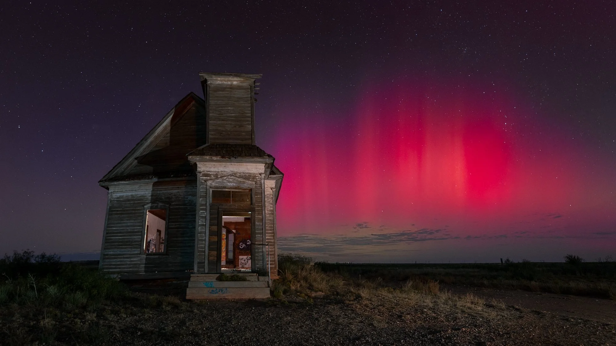 NIGHTSCAPES HONORABLE MENTION: LAUREN BACA - "Lady Aurora's Liturgy," 
On a night when the heavens broke their silence, I followed a whisper of hope. The sky was calm, almost disbelieving, yet my anticipation burned as bright as the red pillars I lon
