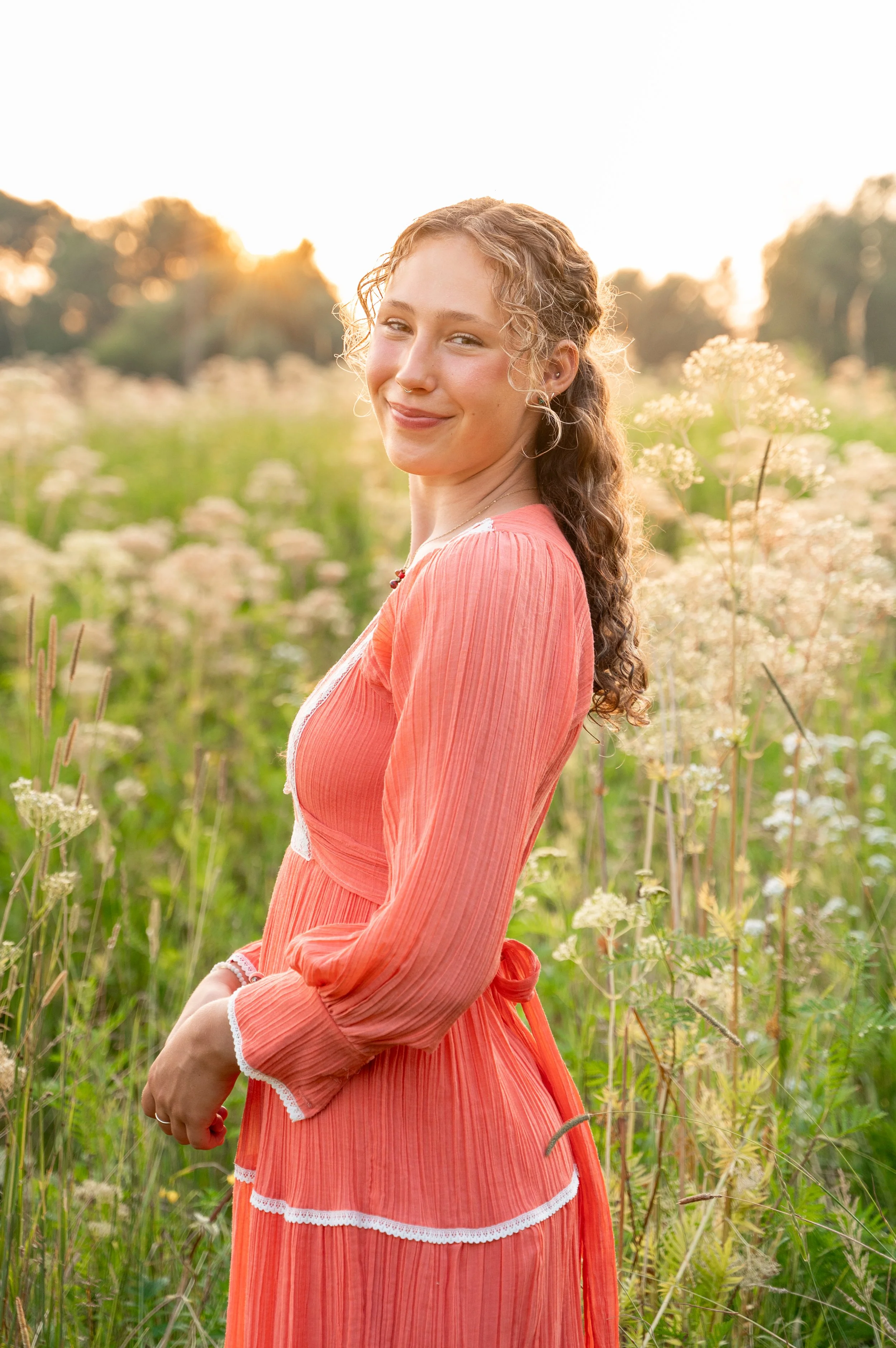 senior girl in a field in wisconsins during golden hour