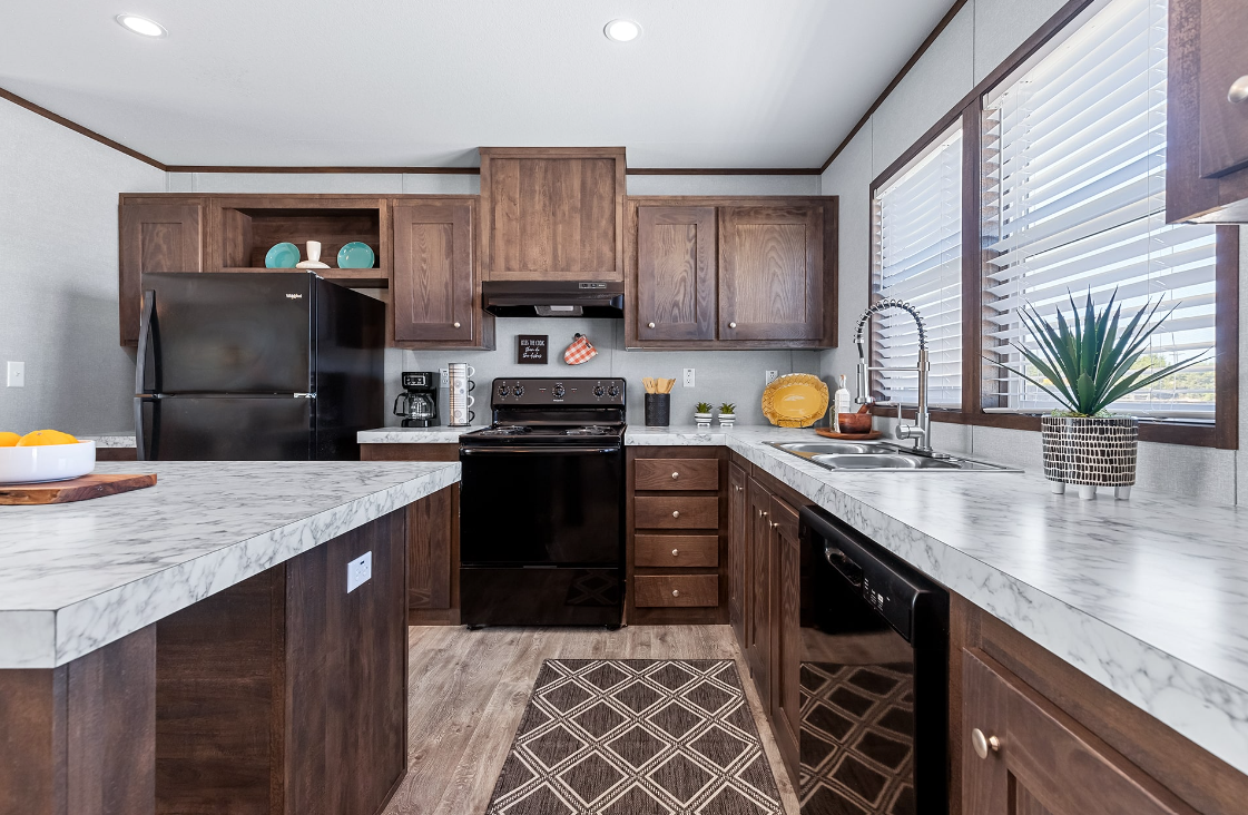Kitchen with dark wood cabinets, marble countertops, black appliances, and a window with blinds, decorated with potted plants and kitchen utensils.