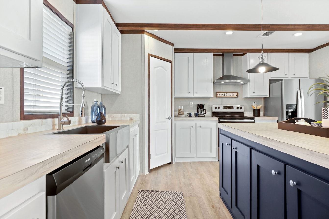 Modern kitchen with white cabinets, black lower cabinets, stainless steel appliances, including a refrigerator and oven, a black coffee maker, and a window with blinds above the sink.