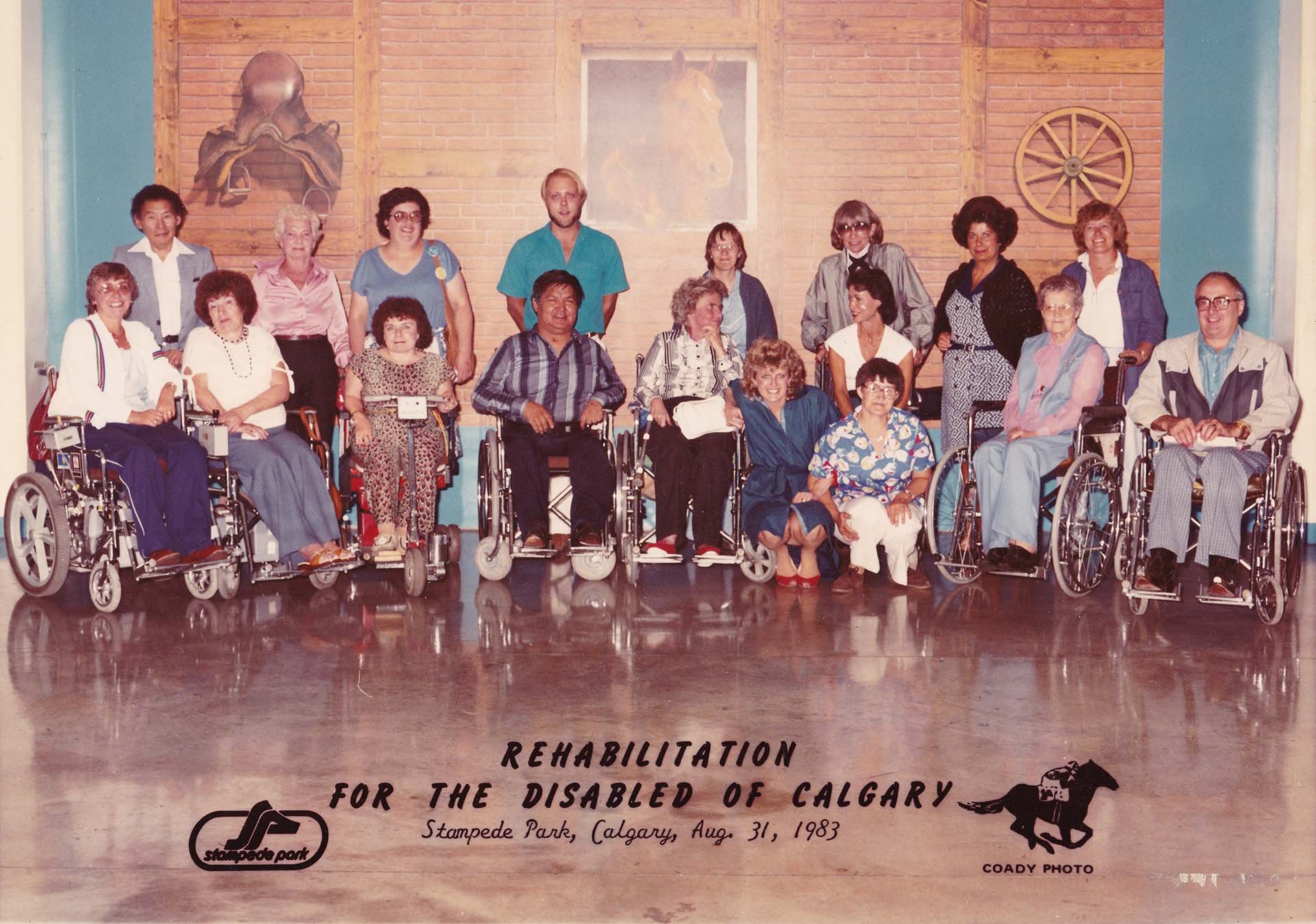 The 18 member Board of Directors, Rehabilitation Society of Calgary, pose for an annual photo with members using wheelchairs in the front row. August 31, 1983