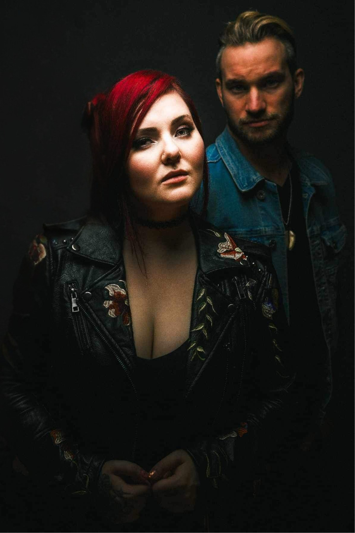 girl with red hair in leather jacket and choker necklace, blonde man in denim jacket