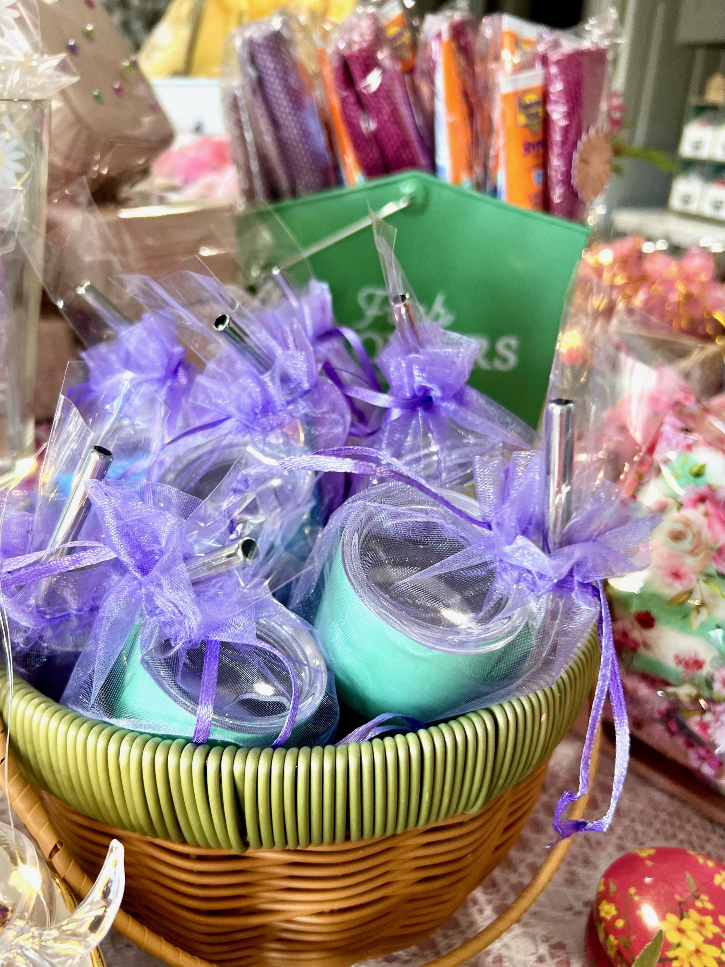 Gift basket with mini teal tumbler shot glass cups wrapped in purple organza bags.
