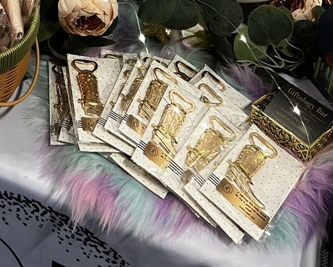 Collection of gold boot-shaped bottle openers on a table display for the Western theme party.